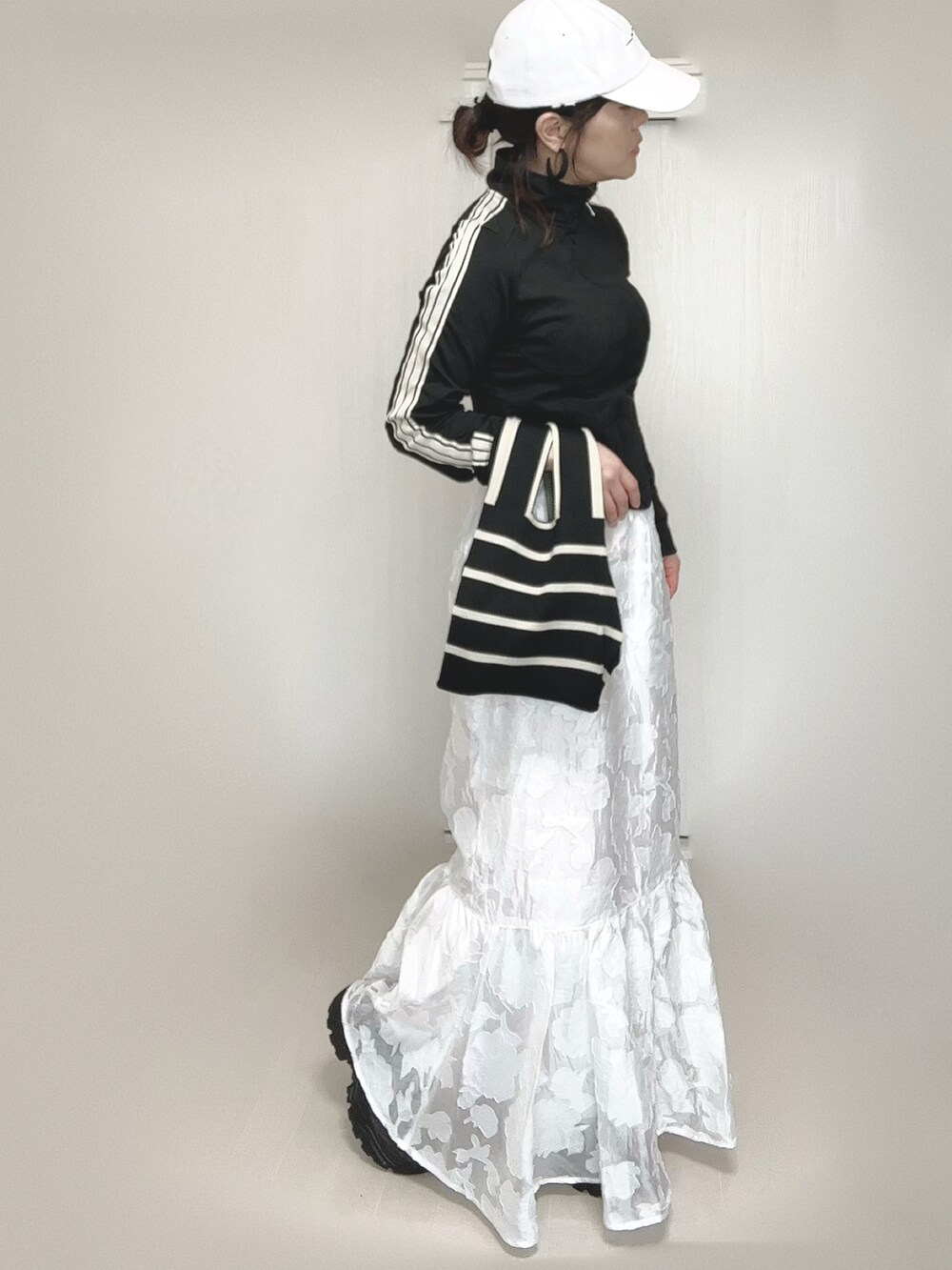 ブラック系のジャージ、その他のトートバッグ、ホワイト系のスカートを着用したレディースの春コーディネートの2枚目の写真