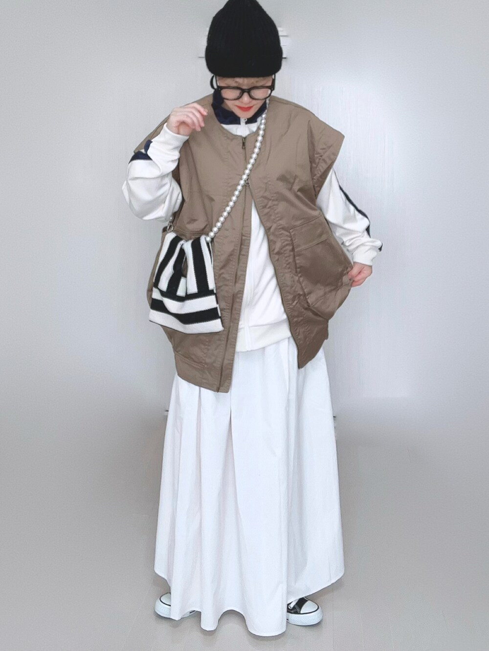 ベージュ系のジャケット/アウター、ベージュ系のジャージ、ホワイト系のショルダーバッグを着用したレディースの冬コーディネートの2枚目の写真