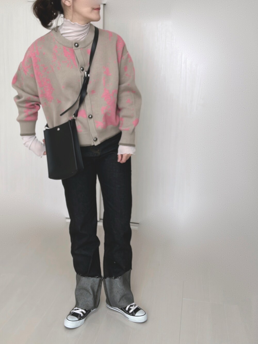 ブラック系のデニムパンツ、ベージュ系のカーディガン/ボレロ、グレー系のTシャツ/カットソーを着用したレディースの冬コーディネートの2枚目の写真
