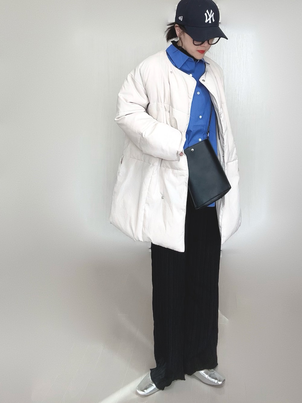 ホワイト系のダウンジャケット/コート、ブルー系のシャツ/ブラウス、ブラック系のショルダーバッグを着用したレディースの冬コーディネートの3枚目の写真