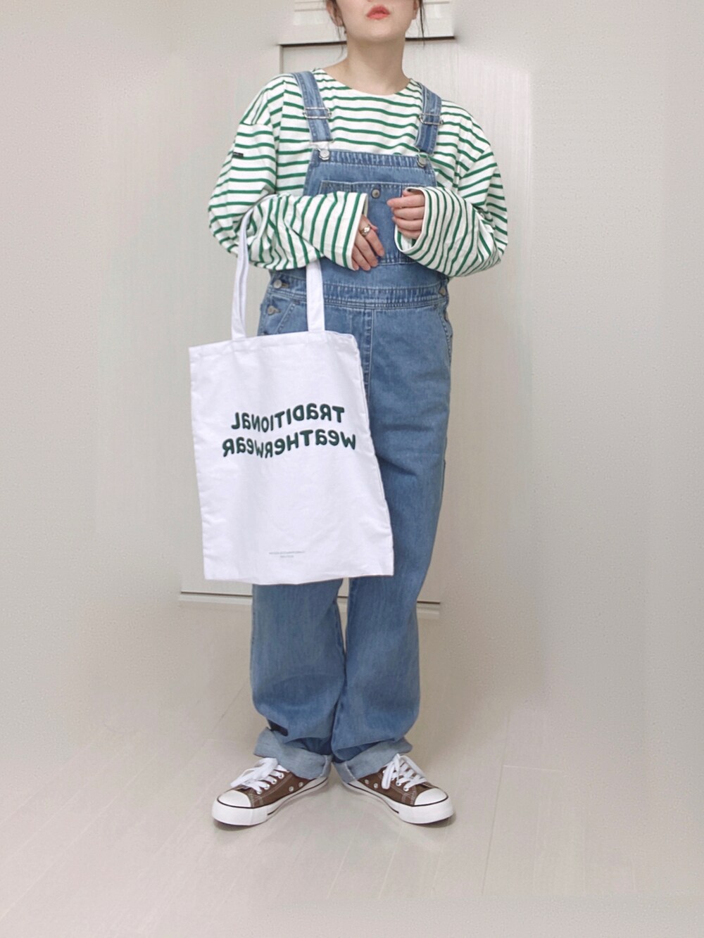 ブルー系のサロペット/オーバーオール、ホワイト系のトートバッグ、ホワイト系のTシャツ/カットソーを着用したレディースの春コーディネートの2枚目の写真