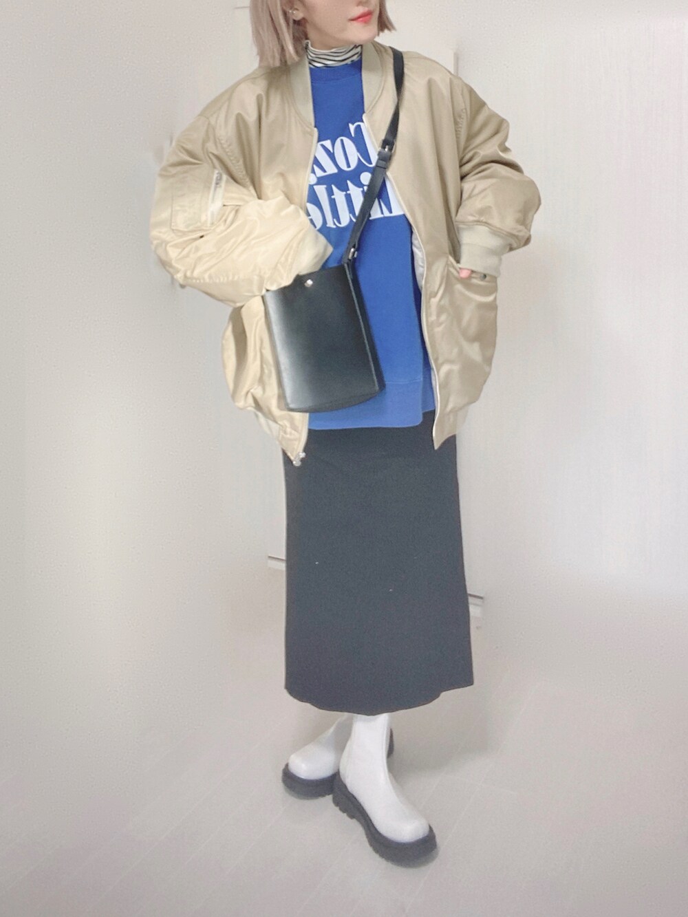 ベージュ系のMA-1、ホワイト系のTシャツ/カットソー、ブルー系のスウェットを着用したレディースの冬コーディネートの5枚目の写真