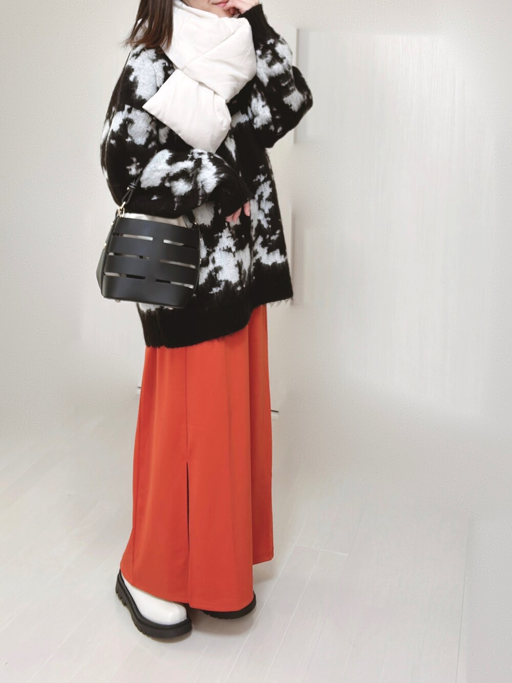 グレー系のノーカラージャケット、ホワイト系のダウンジャケット/コート、ブラック系のニット/セーターを着用したレディースの冬コーディネートの5枚目の写真