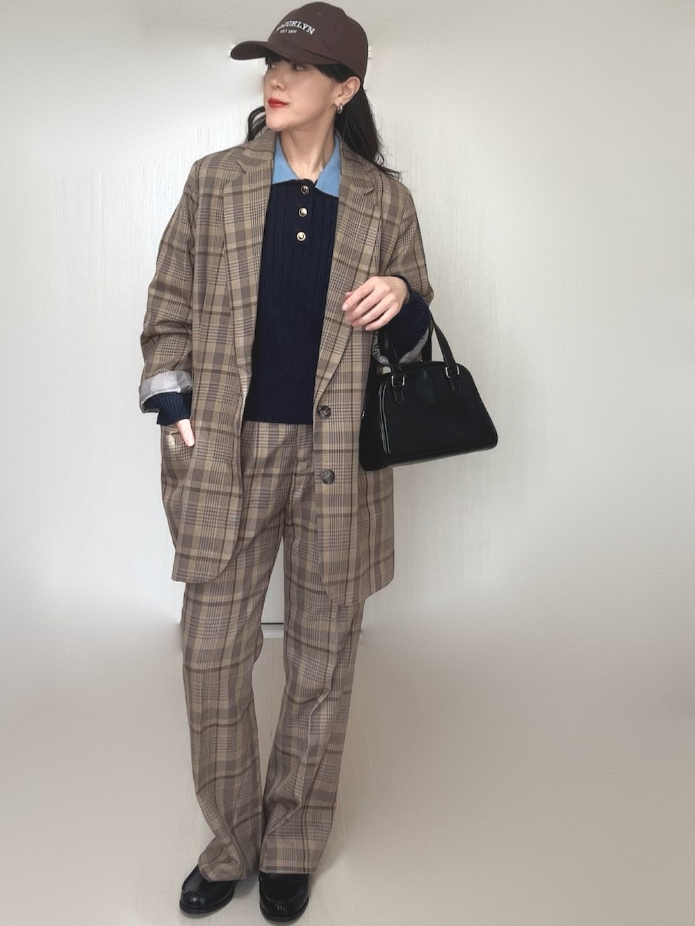 ブルー系のニット/セーター、ブラック系のボストンバッグ、ブラック系のローファーを着用したレディースの冬コーディネートの4枚目の写真