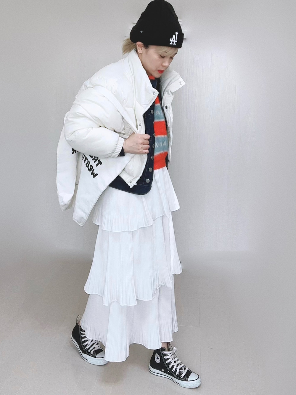 ホワイト系のダウンジャケット/コート、ブルー系のデニムジャケット、オレンジ系のニット/セーターを着用したレディースの冬コーディネートの3枚目の写真