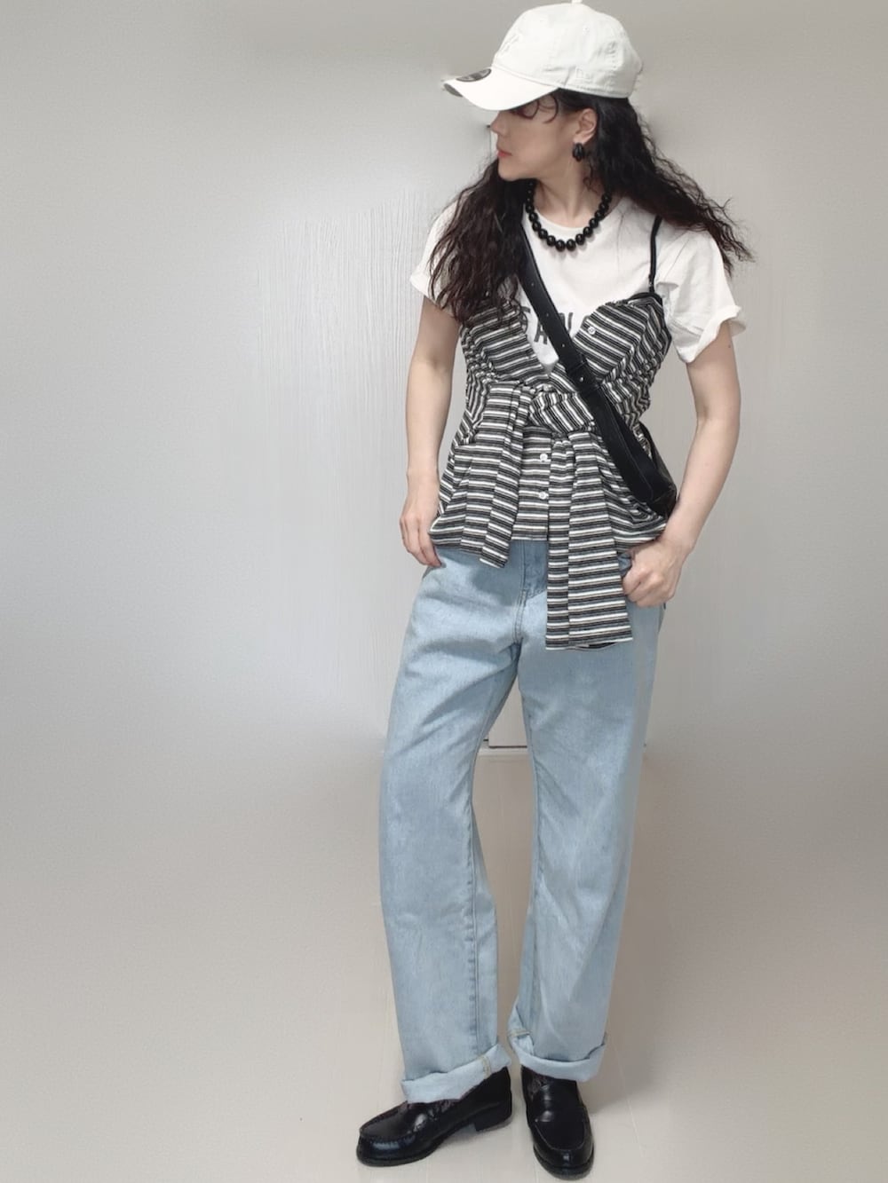 ホワイト系のTシャツ/カットソー、グレー系のカーディガン/ボレロ、ブルー系のデニムパンツを着用したレディースの春コーディネートの5枚目の写真