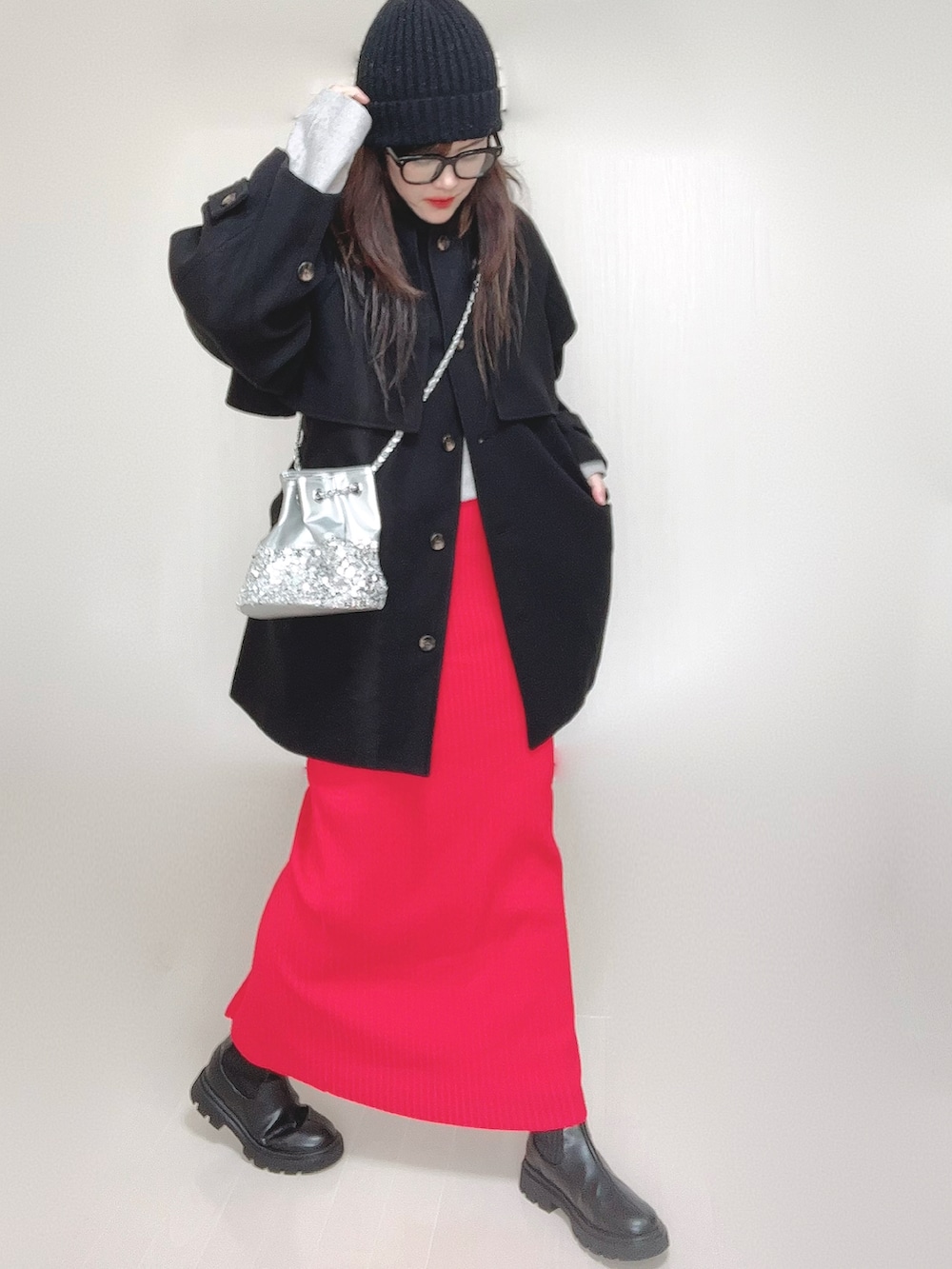 グレー系のトレンチコート、グレー系のワンピース、シルバー系のショルダーバッグを着用したレディースの秋コーディネートの2枚目の写真