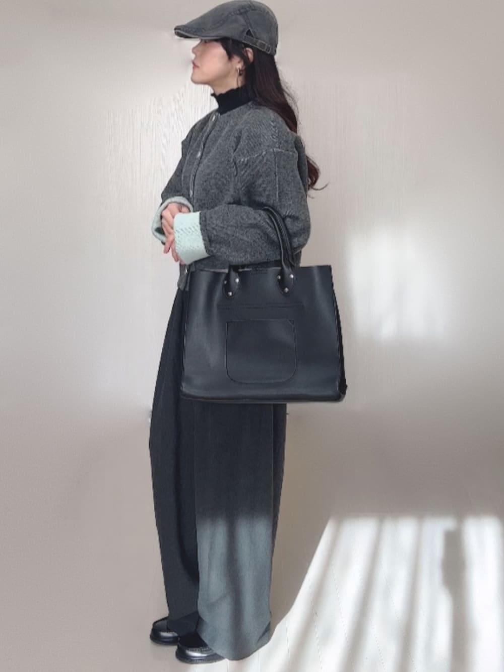 グレー系のカーディガン/ボレロ、ブラック系のローファー、グレー系のスラックスを着用したレディースの冬コーディネートの5枚目の写真