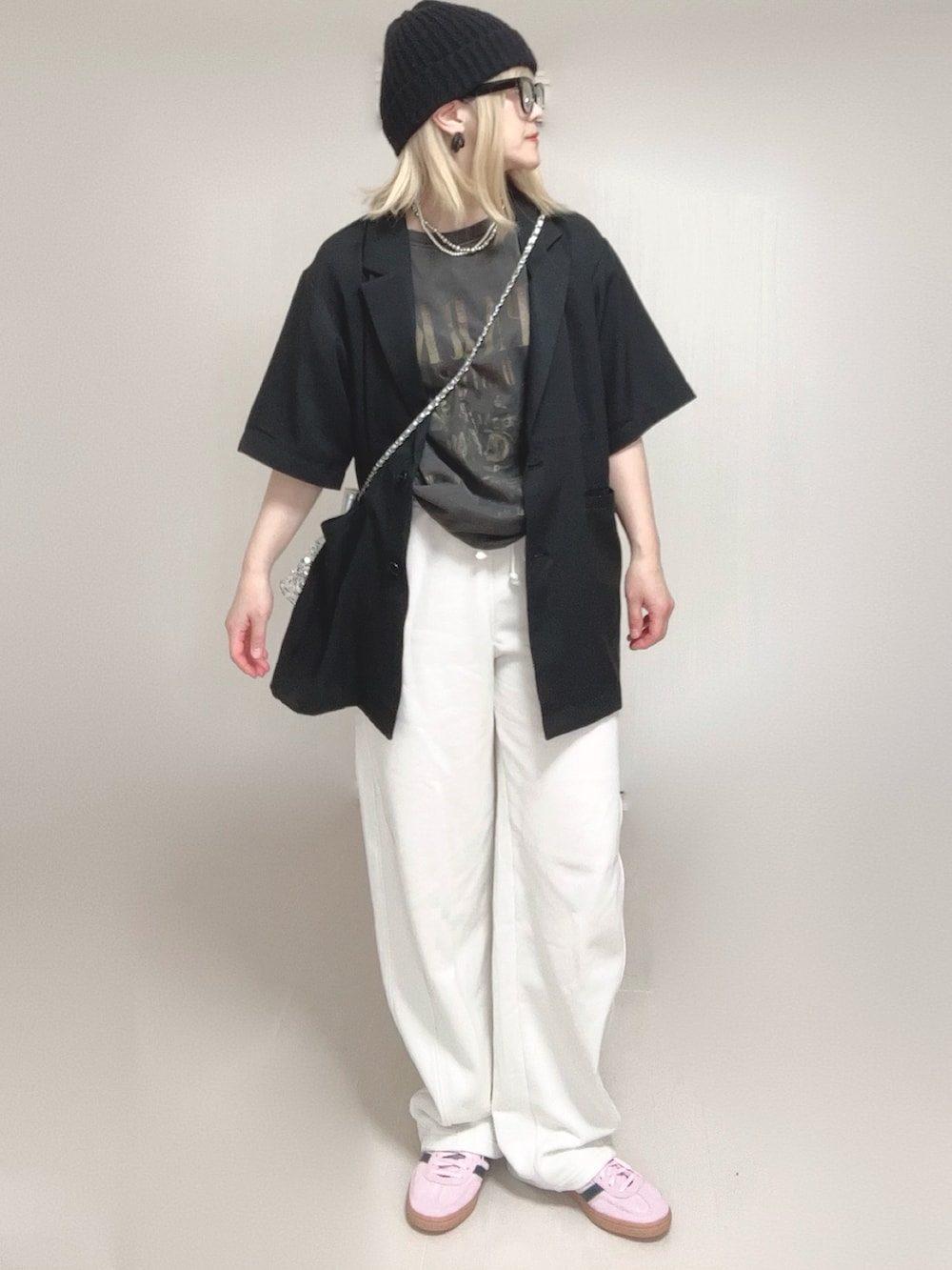 ブラック系のテーラードジャケット、ブラック系のTシャツ/カットソー、ピンク系のスニーカーを着用したレディースの春コーディネートの4枚目の写真