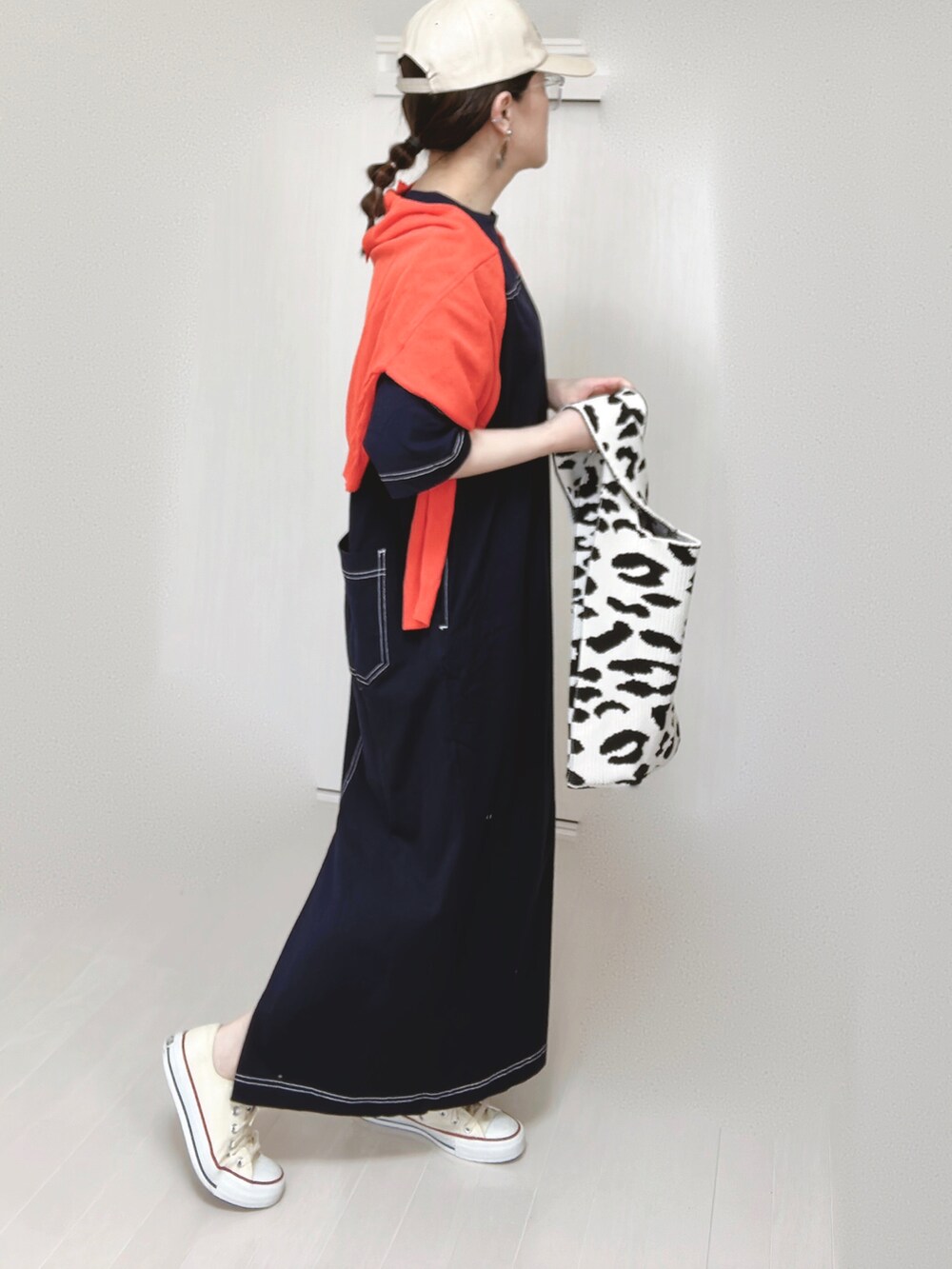 ブルー系のワンピース、オレンジ系のカーディガン/ボレロ、ホワイト系のスニーカーを着用したレディースの春コーディネートの4枚目の写真