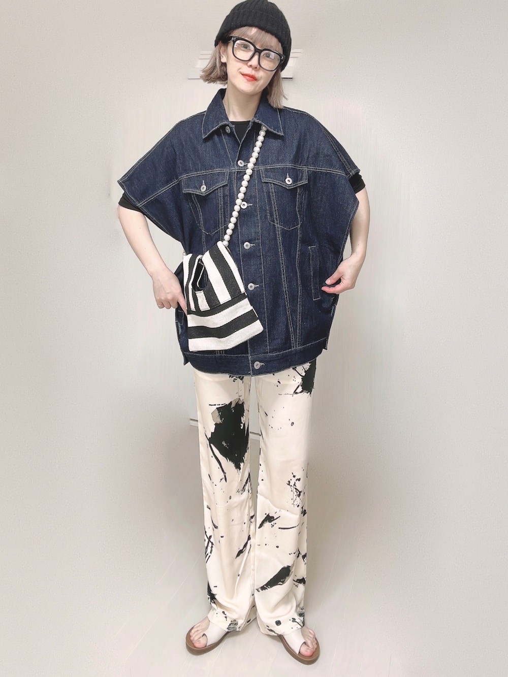 ブルー系のベスト、ブラック系のTシャツ/カットソー、ホワイト系のショルダーバッグを着用したレディースの春コーディネートの5枚目の写真