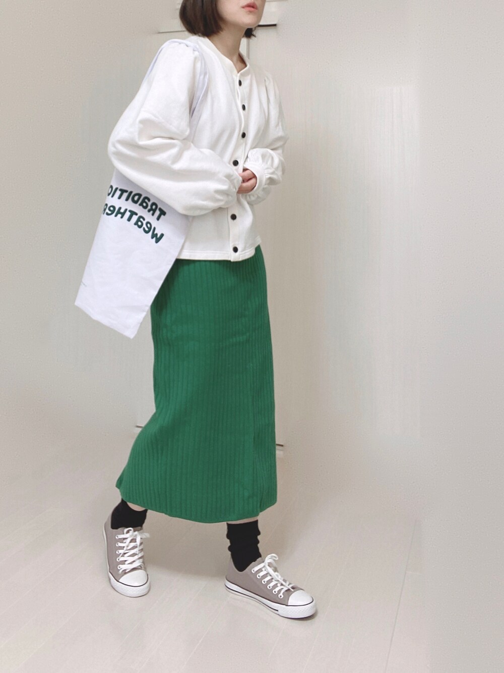 ブラック系のカーディガン/ボレロ、ホワイト系のトートバッグ、グリーン系のスカートを着用したレディースの春コーディネートの2枚目の写真