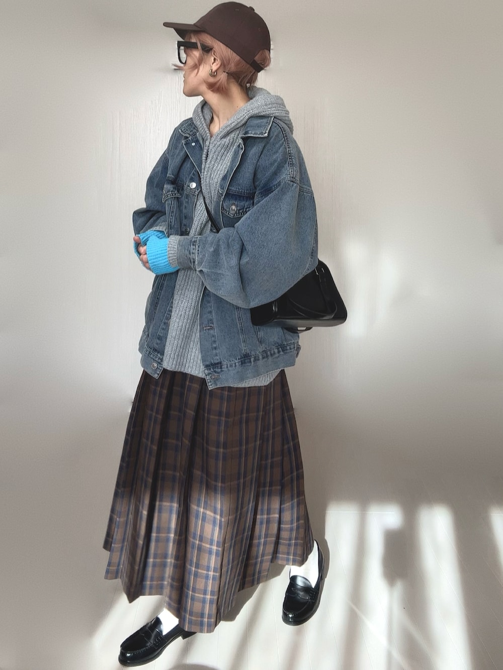 グレー系のニット/セーター、ブルー系のデニムジャケット、ブラウン系のスカートを着用したレディースの冬コーディネートの3枚目の写真