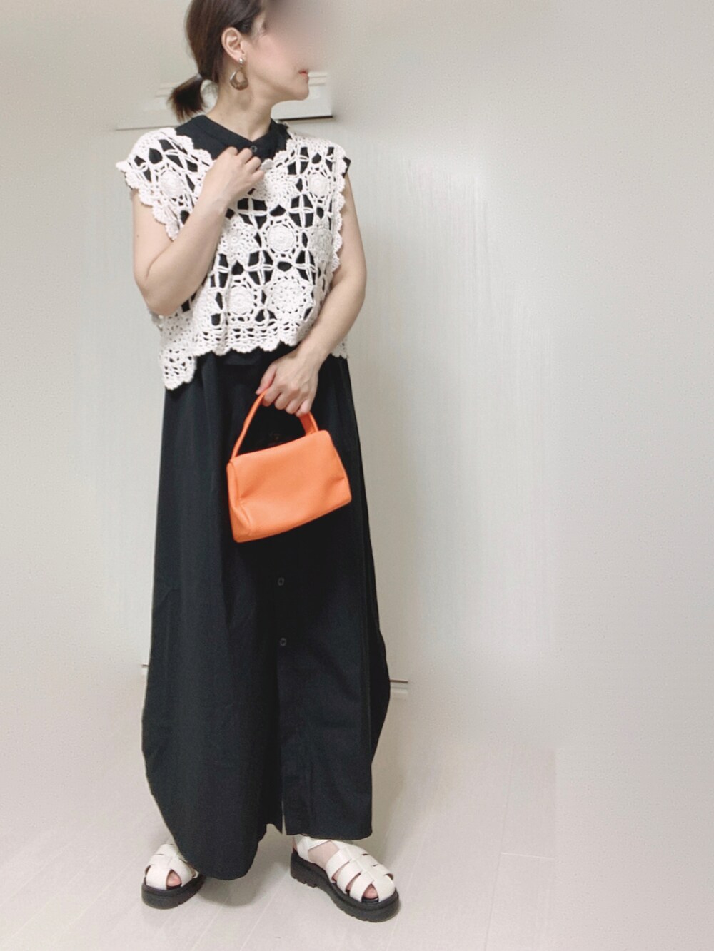 ブラック系のワンピース、オレンジ系のショルダーバッグを着用したレディースの夏コーディネートの5枚目の写真