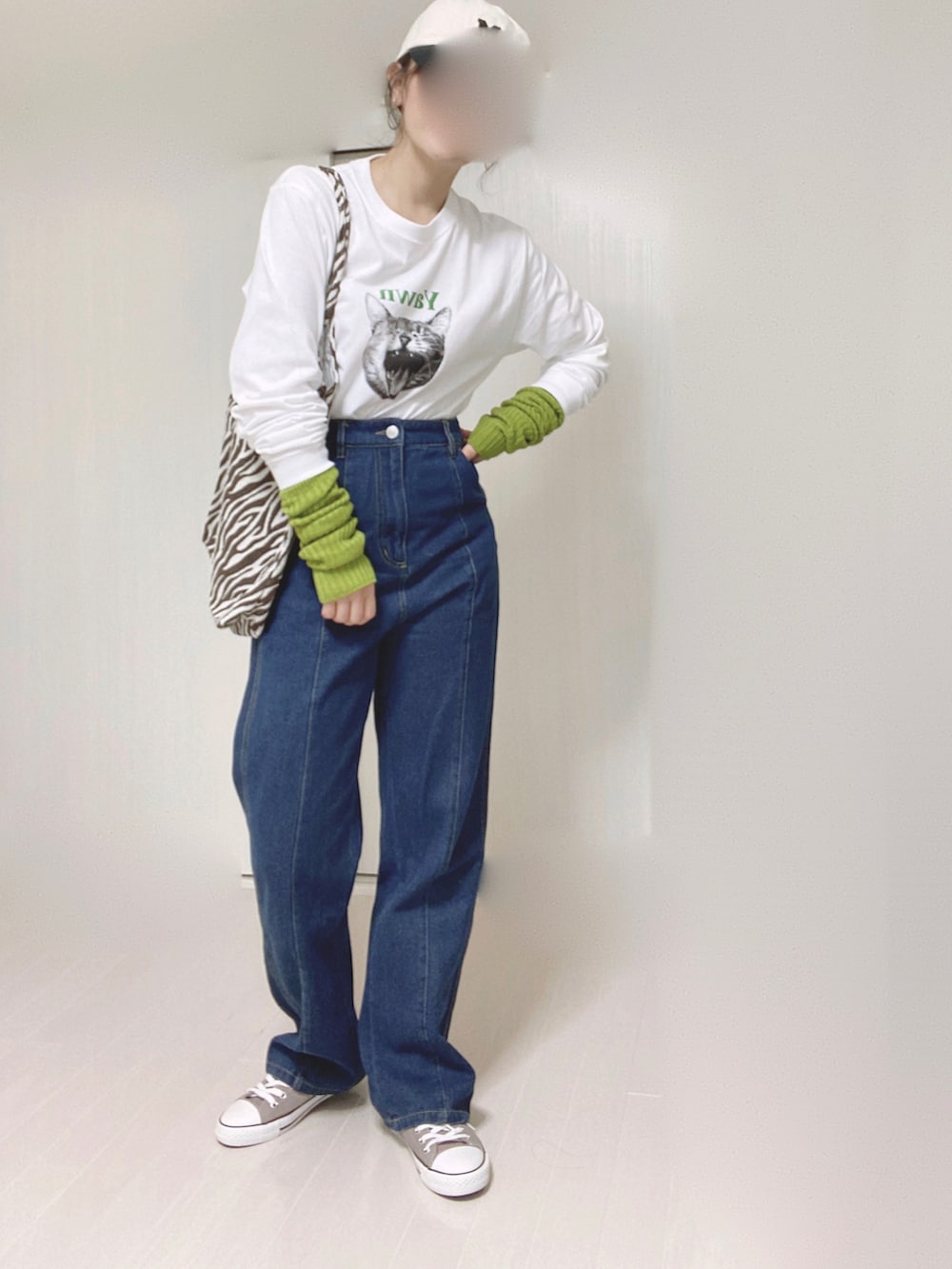 ホワイト系のTシャツ/カットソー、ブルー系のデニムパンツ、グリーン系のアームカバーを着用したレディースの秋コーディネートの2枚目の写真