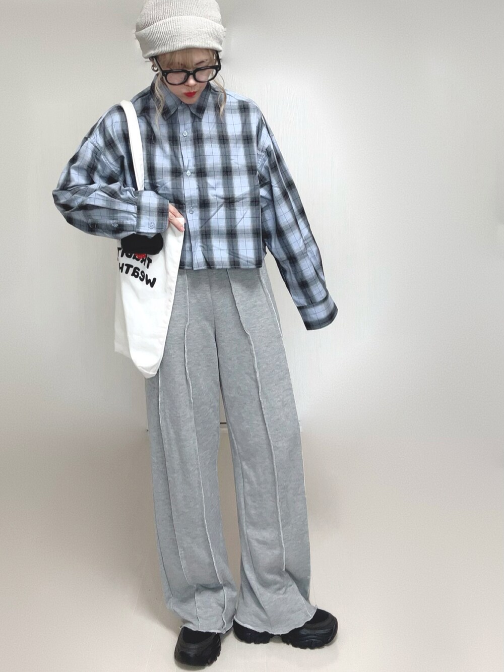 ブルー系のシャツ/ブラウス、グレー系のスウェットパンツ、ホワイト系のトートバッグを着用したレディースの秋コーディネートの3枚目の写真