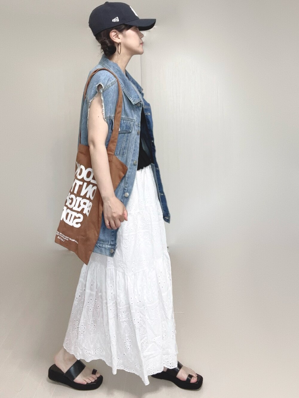 ブラック系のキャミソール、ブラウン系のトートバッグ、ブラック系のサンダルを着用したレディースの夏コーディネートの2枚目の写真