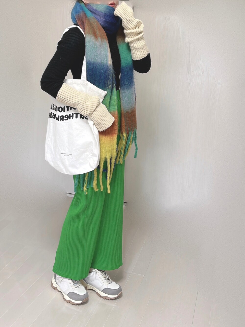 ホワイト系のトートバッグ、グリーン系のスカート、ベージュ系のスニーカーを着用したレディースの冬コーディネートの3枚目の写真