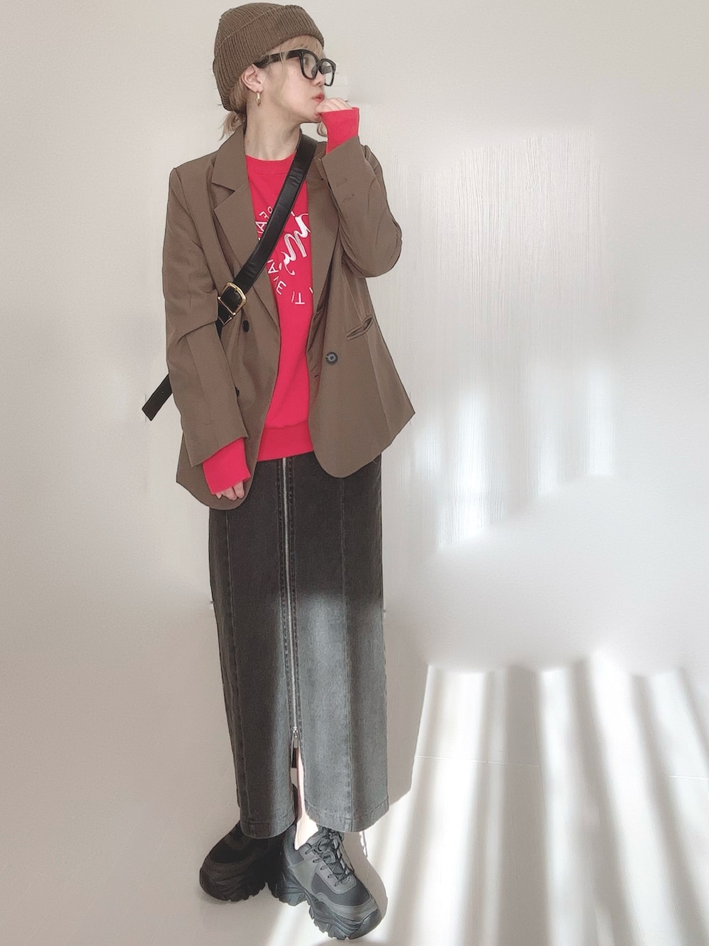 ブラック系のスカート、ブラウン系のテーラードジャケット、レッド系のスウェットを着用したレディースの冬コーディネートの5枚目の写真