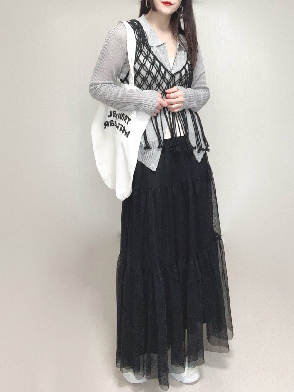 グレー系のカーディガン/ボレロ、ブラック系のスカート、ブラック系のベストを着用したレディースの春コーディネートの3枚目の写真