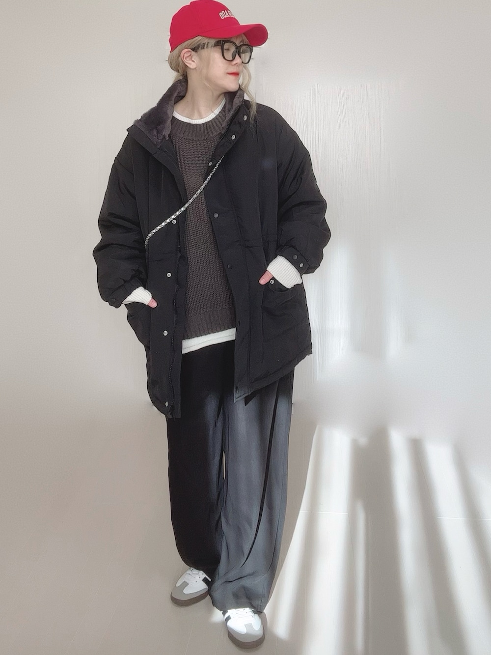 ブラック系のブルゾン、グレー系のニット/セーター、シルバー系のショルダーバッグを着用したレディースの冬コーディネートの2枚目の写真