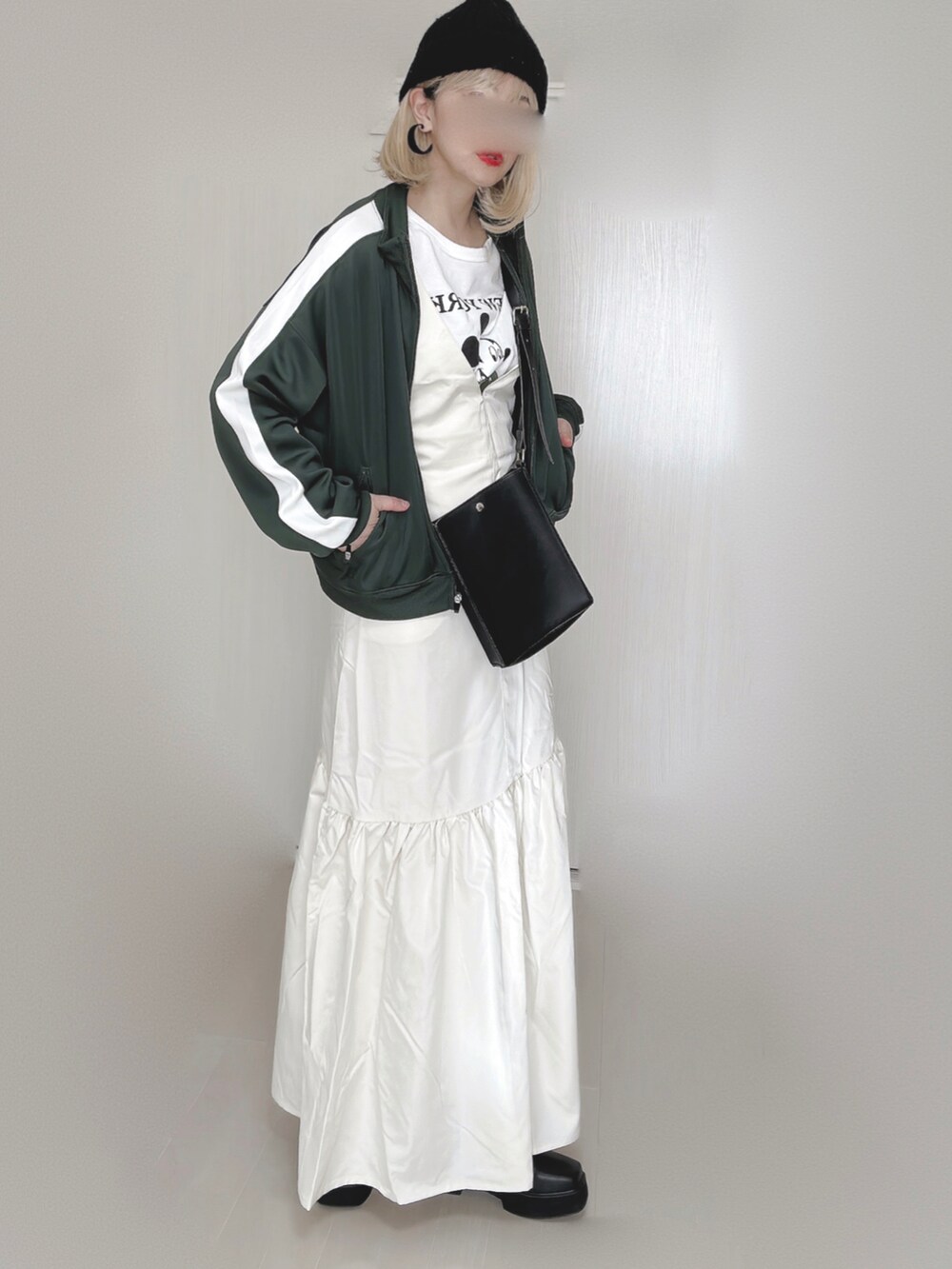 ホワイト系のジャンパースカート、グリーン系のその他アウター、ホワイト系のTシャツ/カットソーを着用したレディースの秋コーディネートの4枚目の写真