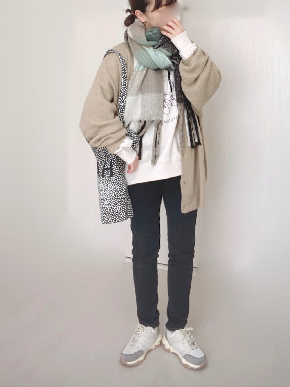 ベージュ系のカーディガン/ボレロ、ブラック系のデニムパンツ、ベージュ系のスニーカーを着用したレディースの冬コーディネートの4枚目の写真