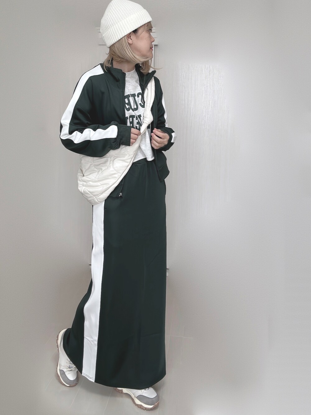 グリーン系のその他アウター、グリーン系のスカート、ホワイト系のショルダーバッグを着用したレディースの秋コーディネートの3枚目の写真