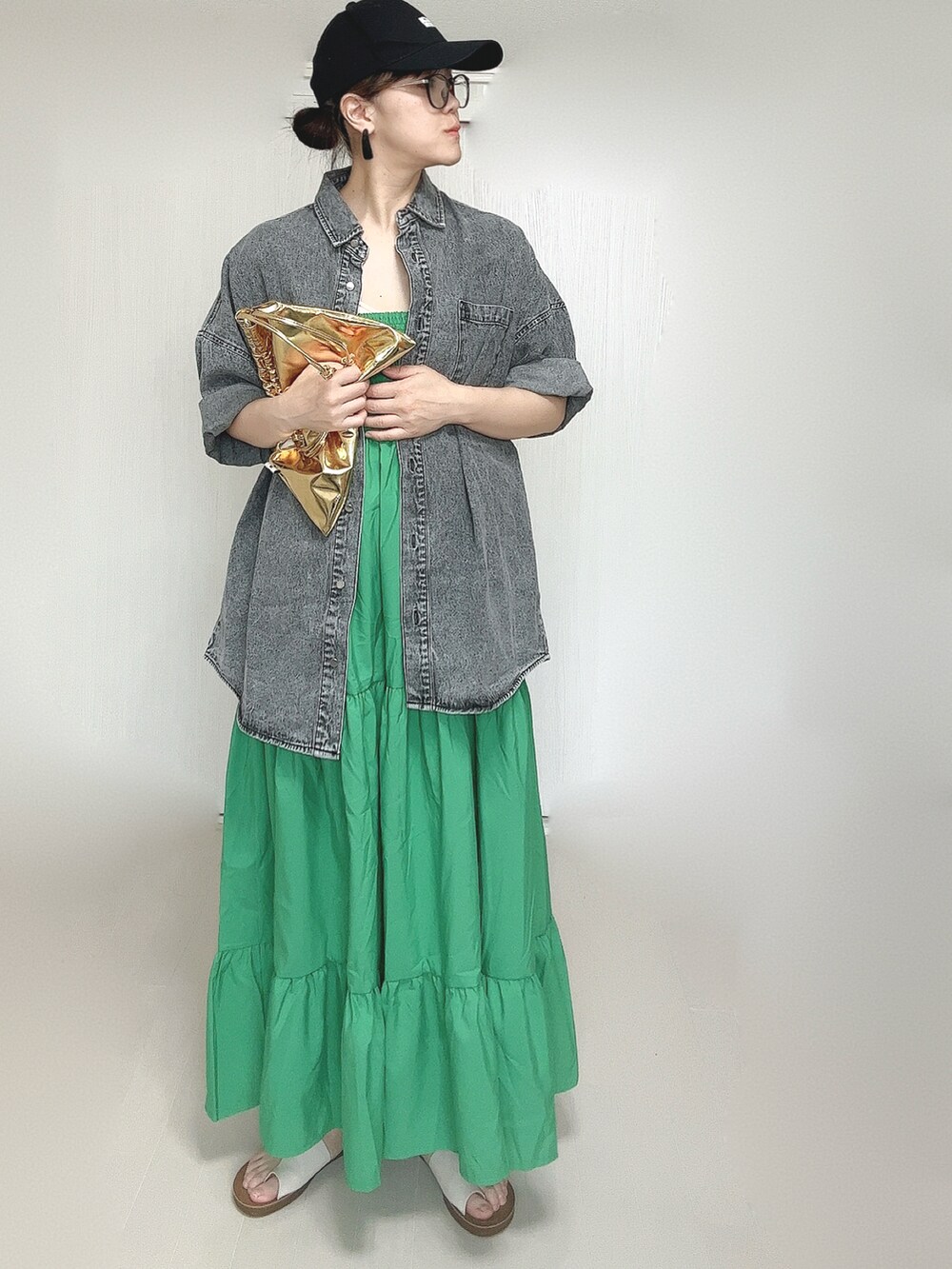 ブラック系のシャツ/ブラウス、ゴールド系のショルダーバッグ、ホワイト系のサンダルを着用したレディースの夏コーディネートの5枚目の写真