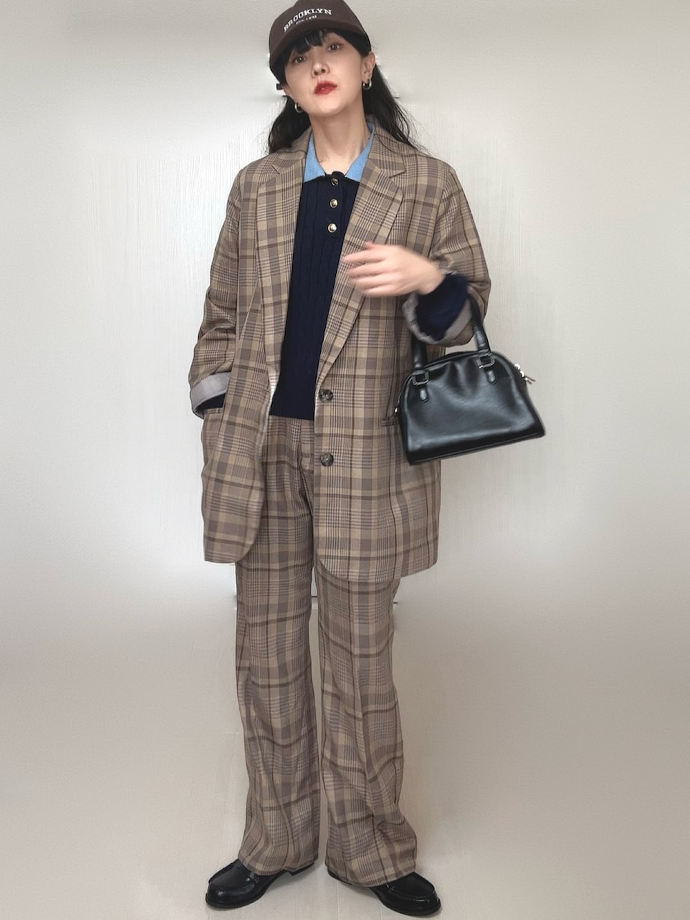 ブルー系のニット/セーター、ブラック系のボストンバッグ、ブラック系のローファーを着用したレディースの冬コーディネートの3枚目の写真