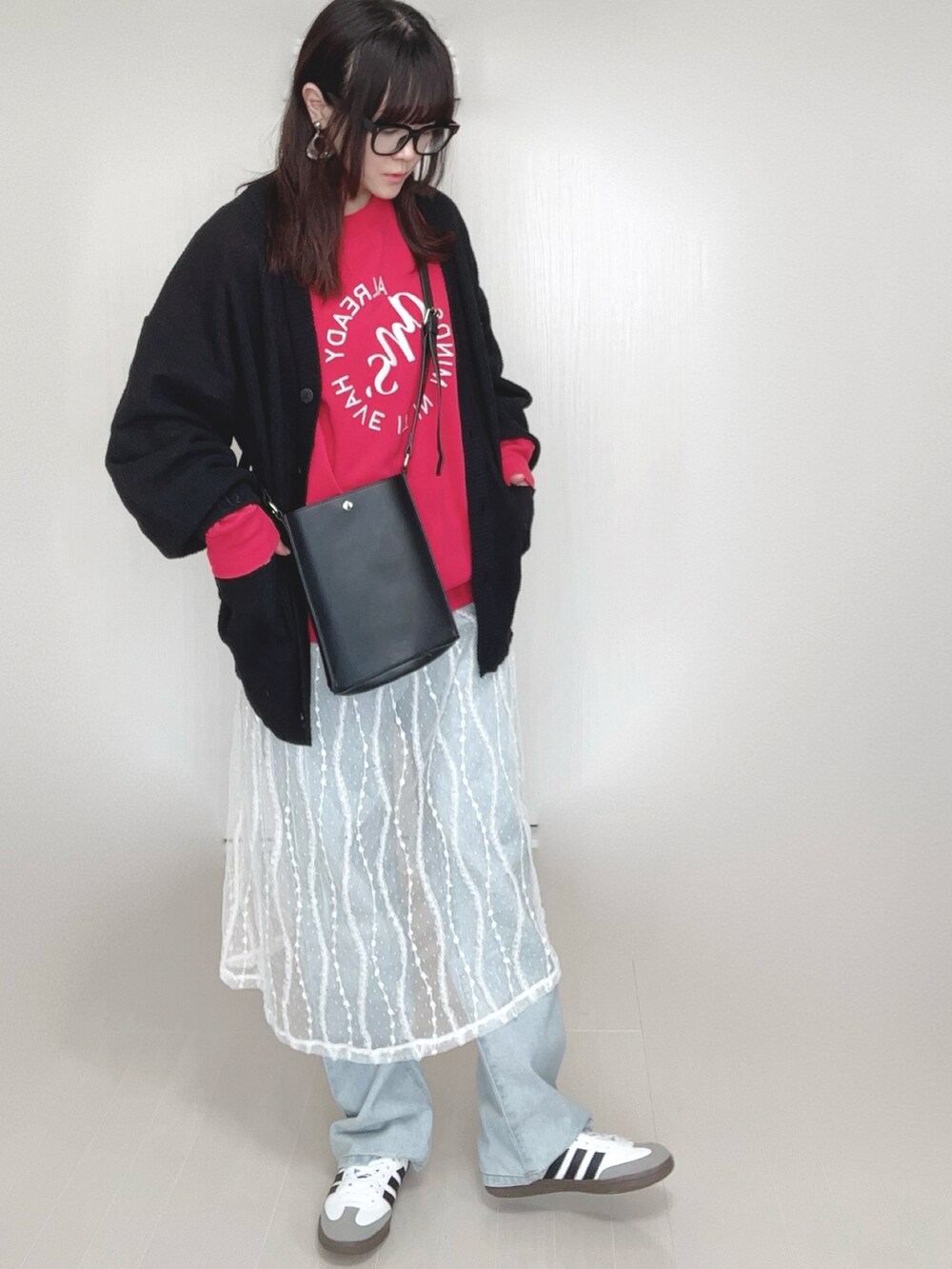 ブラック系のカーディガン/ボレロ、レッド系のスウェット、ブラック系のショルダーバッグを着用したレディースの春コーディネートの2枚目の写真