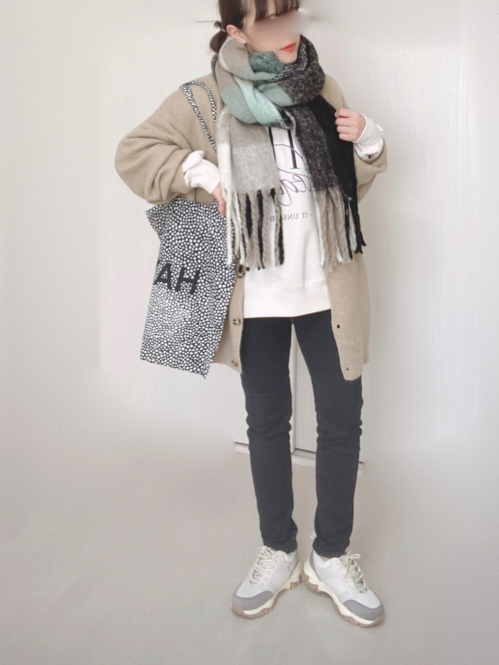 ベージュ系のカーディガン/ボレロ、ブラック系のデニムパンツ、ベージュ系のスニーカーを着用したレディースの冬コーディネートの5枚目の写真
