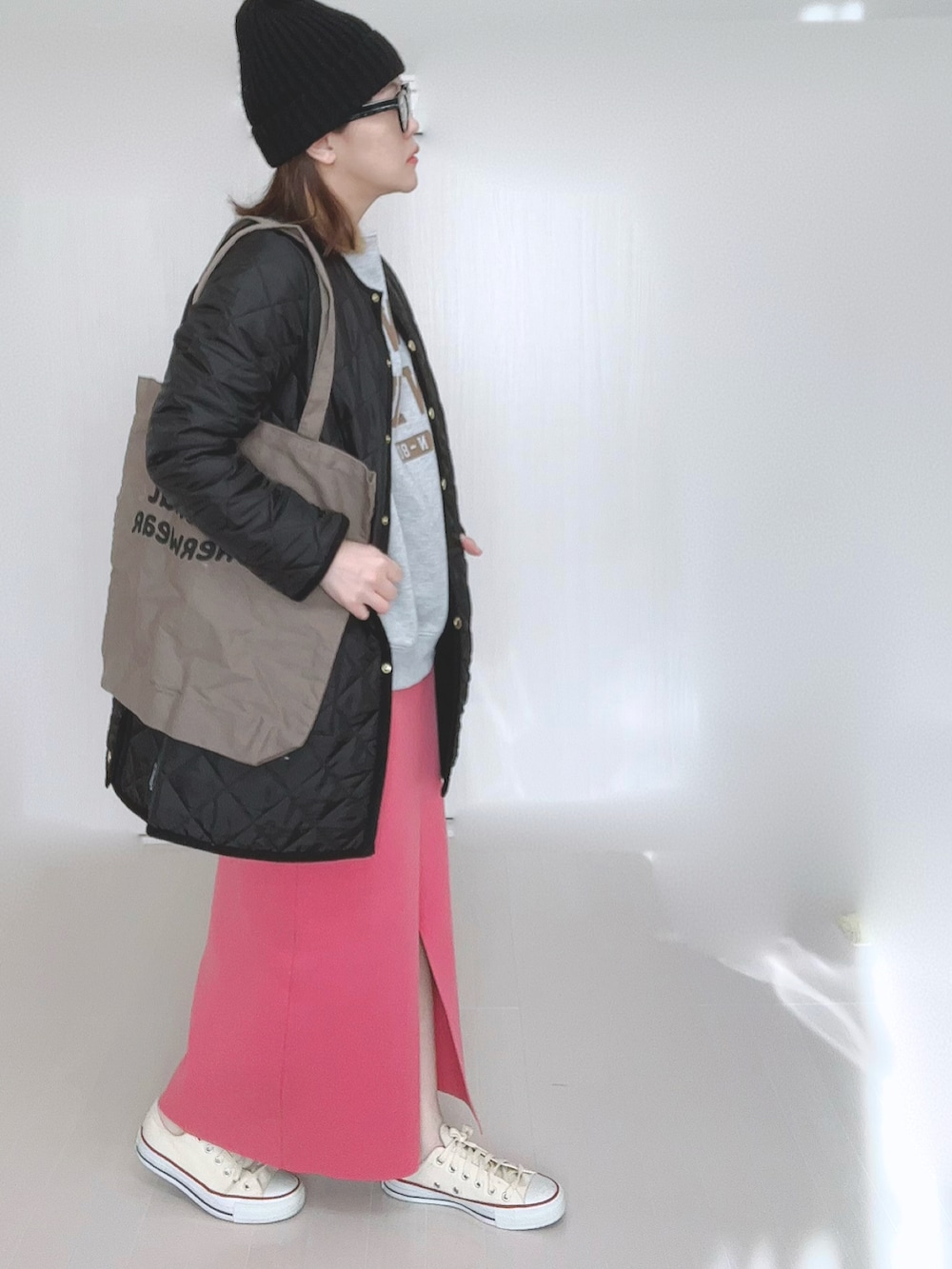 グレー系のスウェット、ブラック系のノーカラーコート、ブラウン系のトートバッグを着用したレディースの冬コーディネートの3枚目の写真