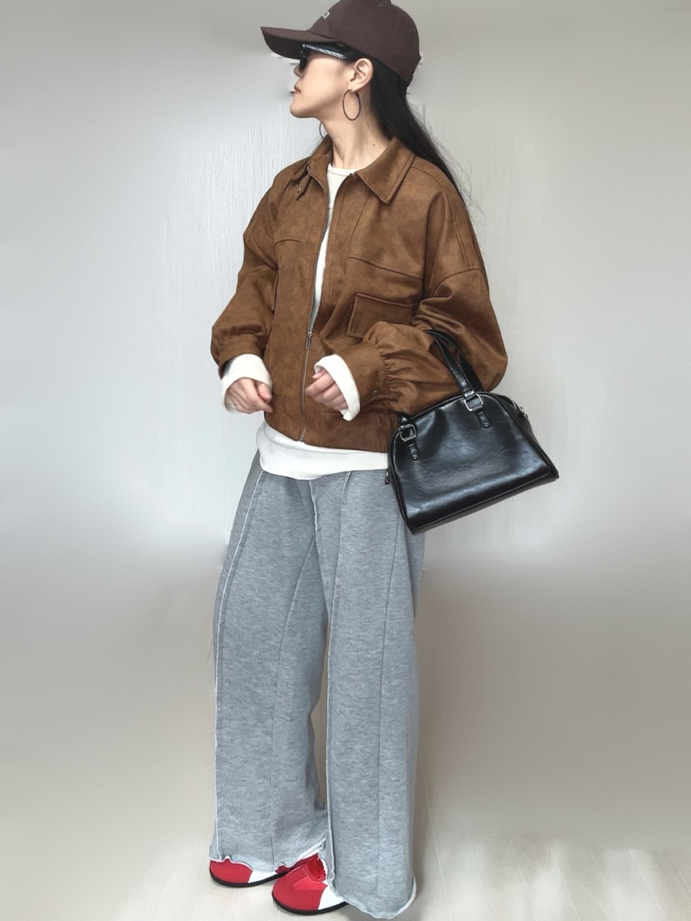 ベージュ系のブルゾン、グレー系のスウェットパンツ、ベージュ系のTシャツ/カットソーを着用したレディースの冬コーディネートの2枚目の写真