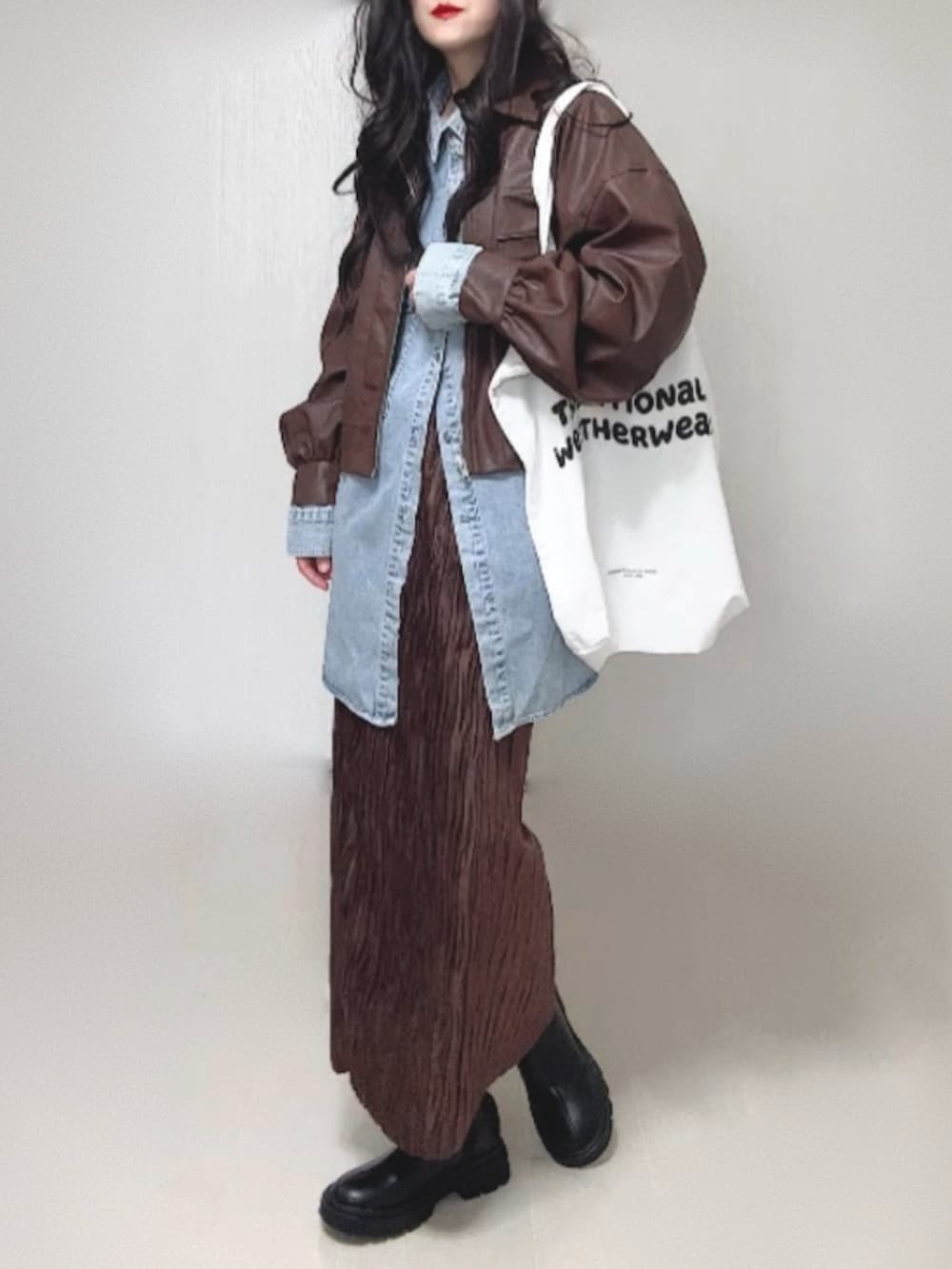 ブルー系のシャツ/ブラウス、ブラウン系のブルゾン、ブラック系のブーツを着用したレディースの冬コーディネートの2枚目の写真