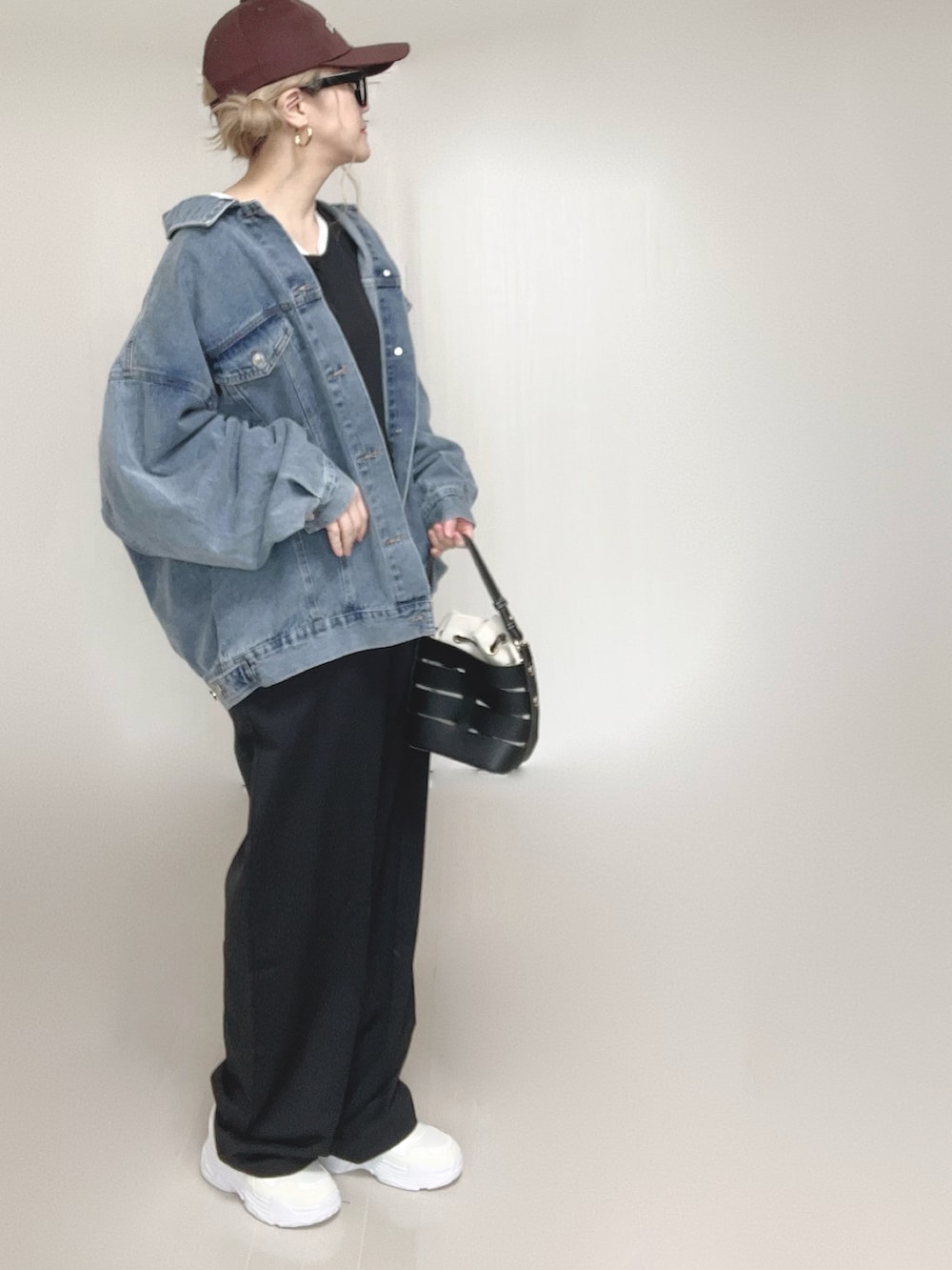 ブルー系のデニムジャケット、ブラック系のつなぎ/オールインワン、ホワイト系のTシャツ/カットソーを着用したレディースの春コーディネートの5枚目の写真