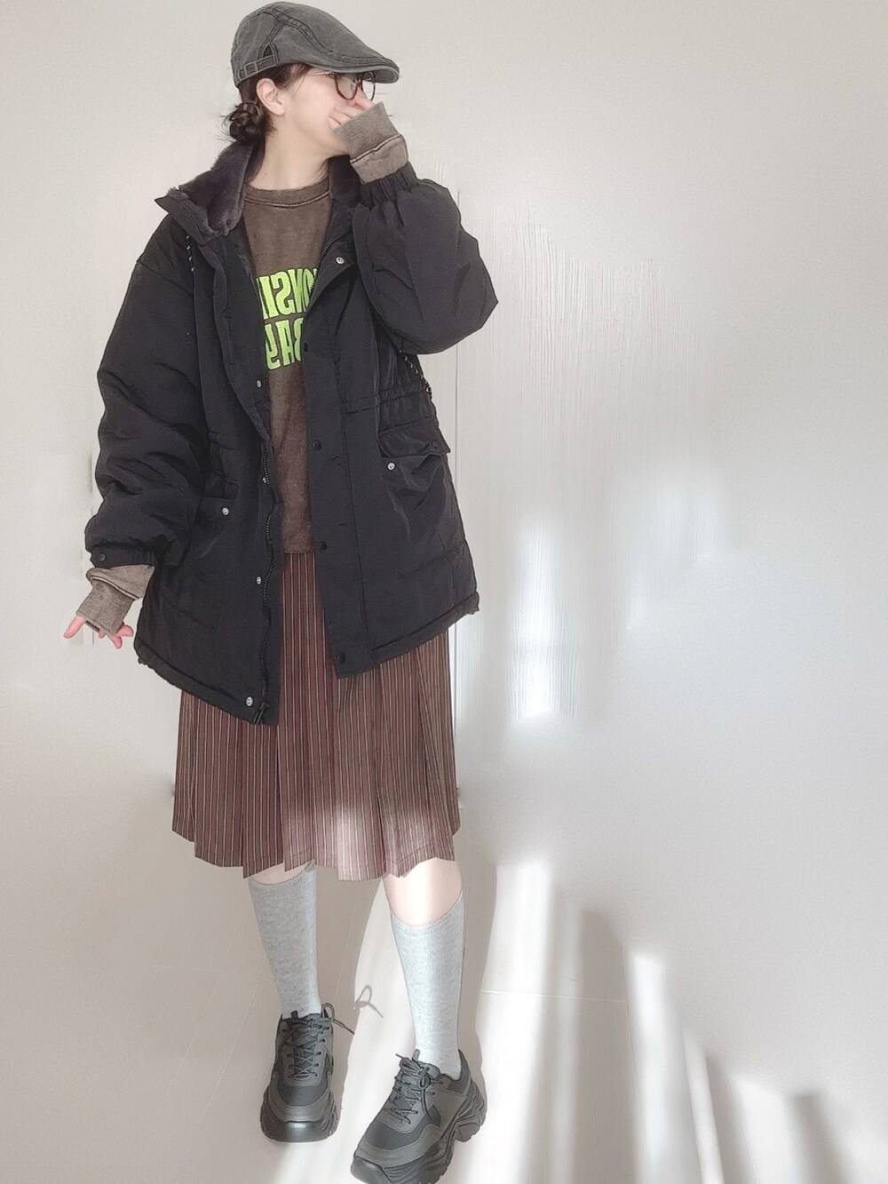 ブラック系のブルゾン、ブラウン系のスウェット、シルバー系のトートバッグを着用したレディースの冬コーディネートの2枚目の写真