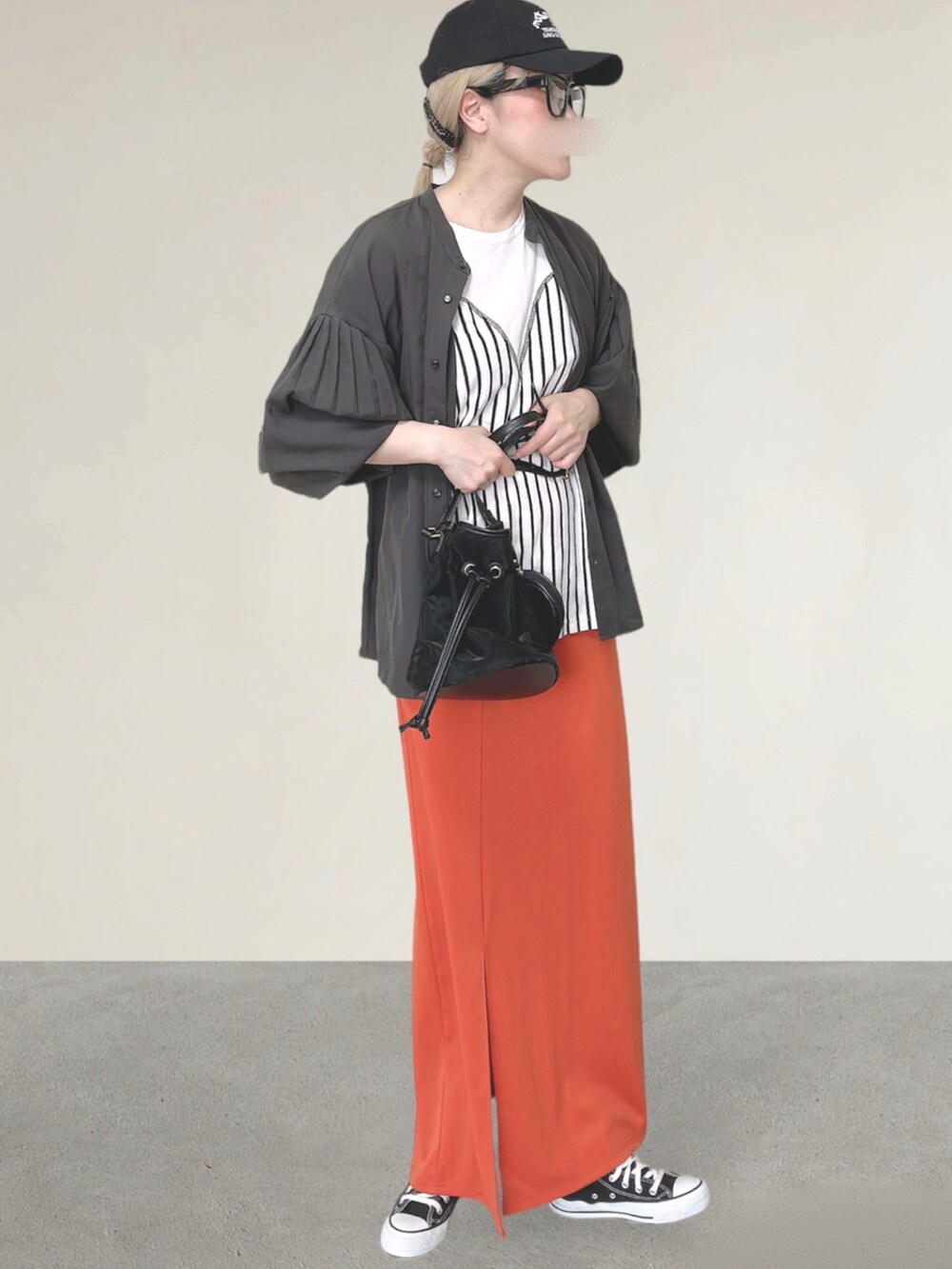 ホワイト系のTシャツ/カットソー、ブラック系のショルダーバッグ、オレンジ系のスカートを着用したレディースの秋コーディネートの5枚目の写真