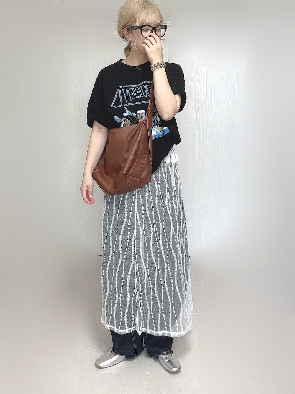 ブラック系のTシャツ/カットソー、ホワイト系のスカート、ブルー系のデニムパンツを着用したレディースの夏コーディネートの2枚目の写真