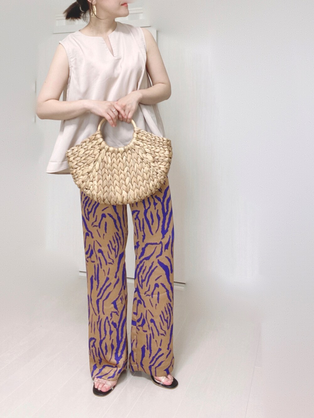 ホワイト系のシャツ/ブラウス、オレンジ系のその他パンツ、ベージュ系のかごバッグを着用したレディースの夏コーディネートの5枚目の写真