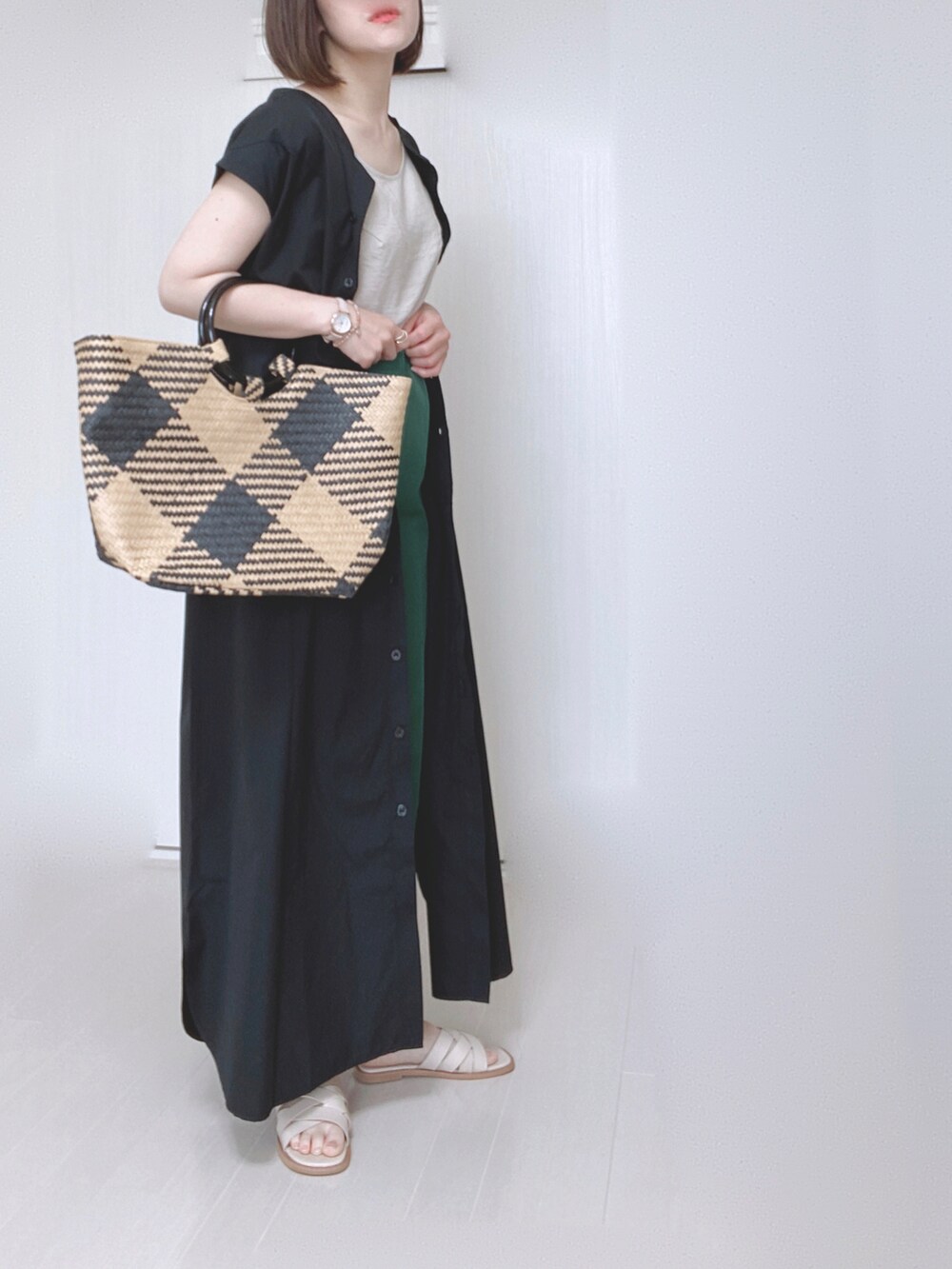 ブラック系のワンピース、ブラック系のトートバッグ、グリーン系のスラックスを着用したレディースの夏コーディネートの2枚目の写真