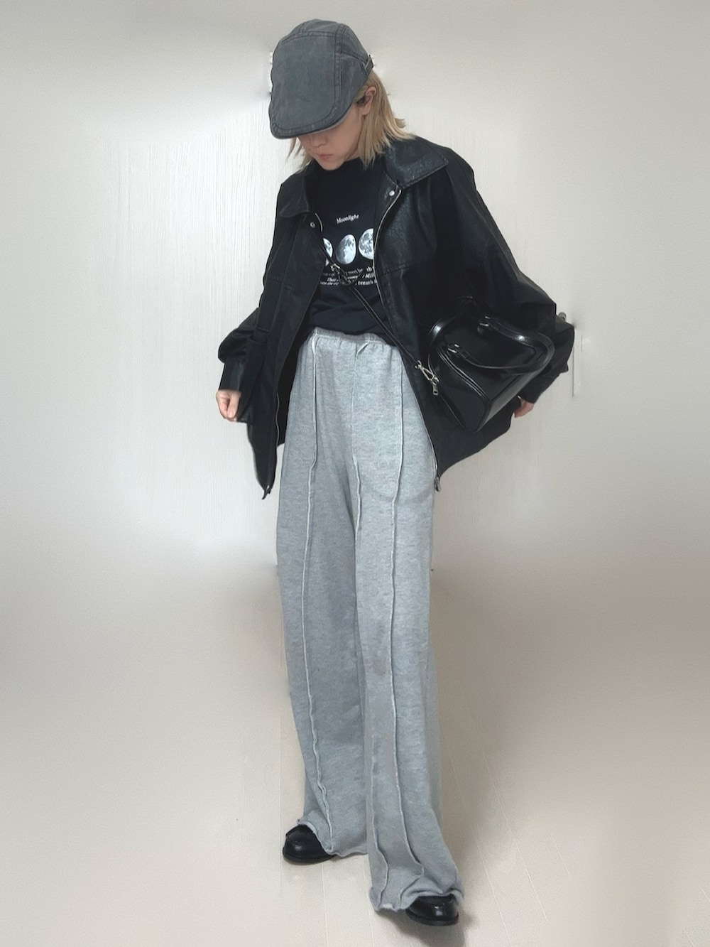 ブラック系のブルゾン、ブラック系のTシャツ/カットソー、グレー系のスウェットパンツを着用したレディースの冬コーディネートの3枚目の写真