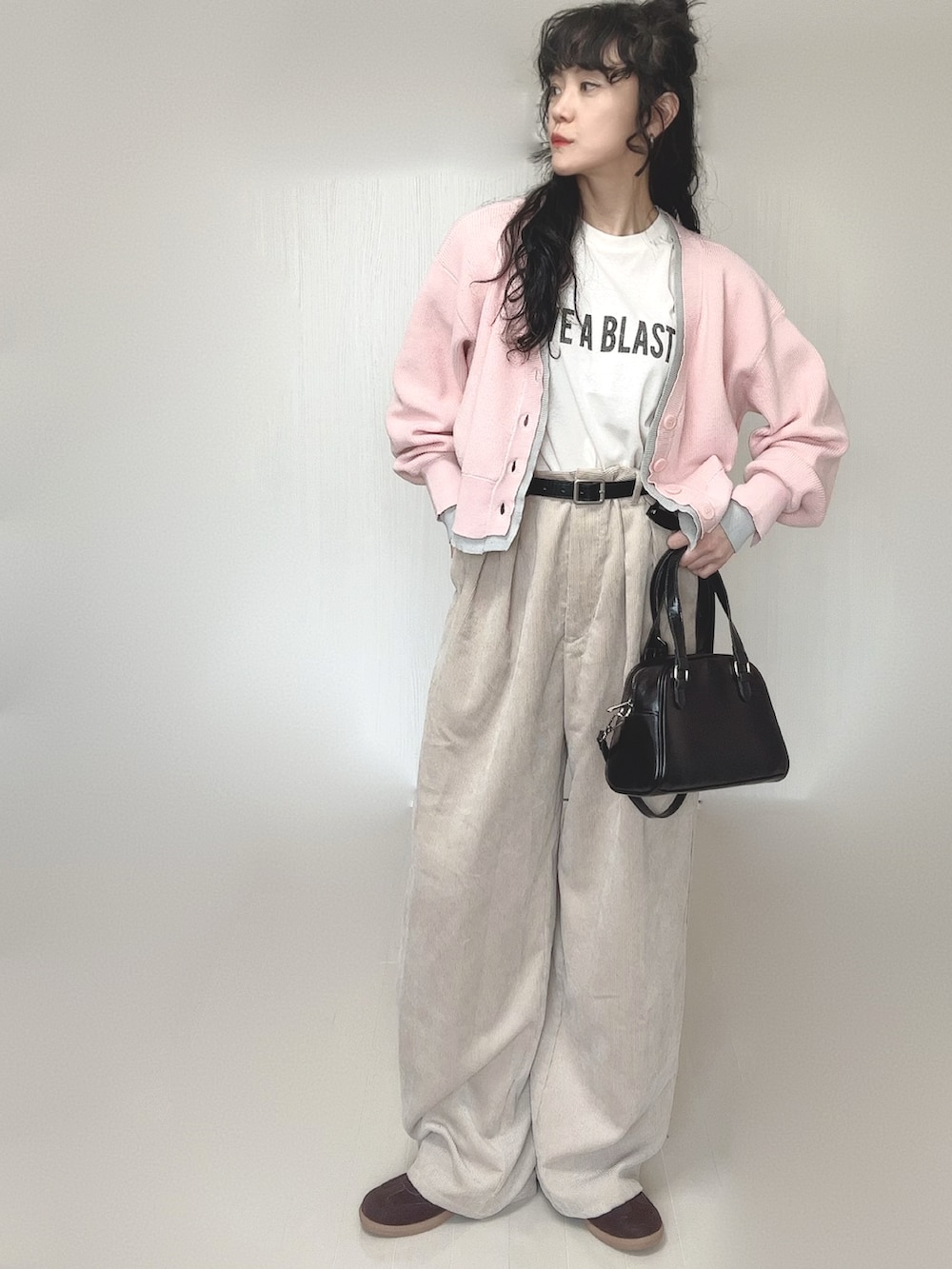 ピンク系のカーディガン/ボレロ、ホワイト系のTシャツ/カットソー、ブラック系のボストンバッグを着用したレディースの春コーディネートの4枚目の写真
