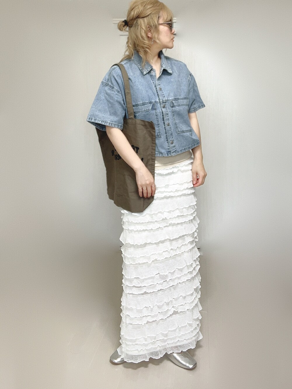 ブルー系のシャツ/ブラウス、ブラウン系のトートバッグ、ホワイト系のスカートを着用したレディースの夏コーディネートの4枚目の写真