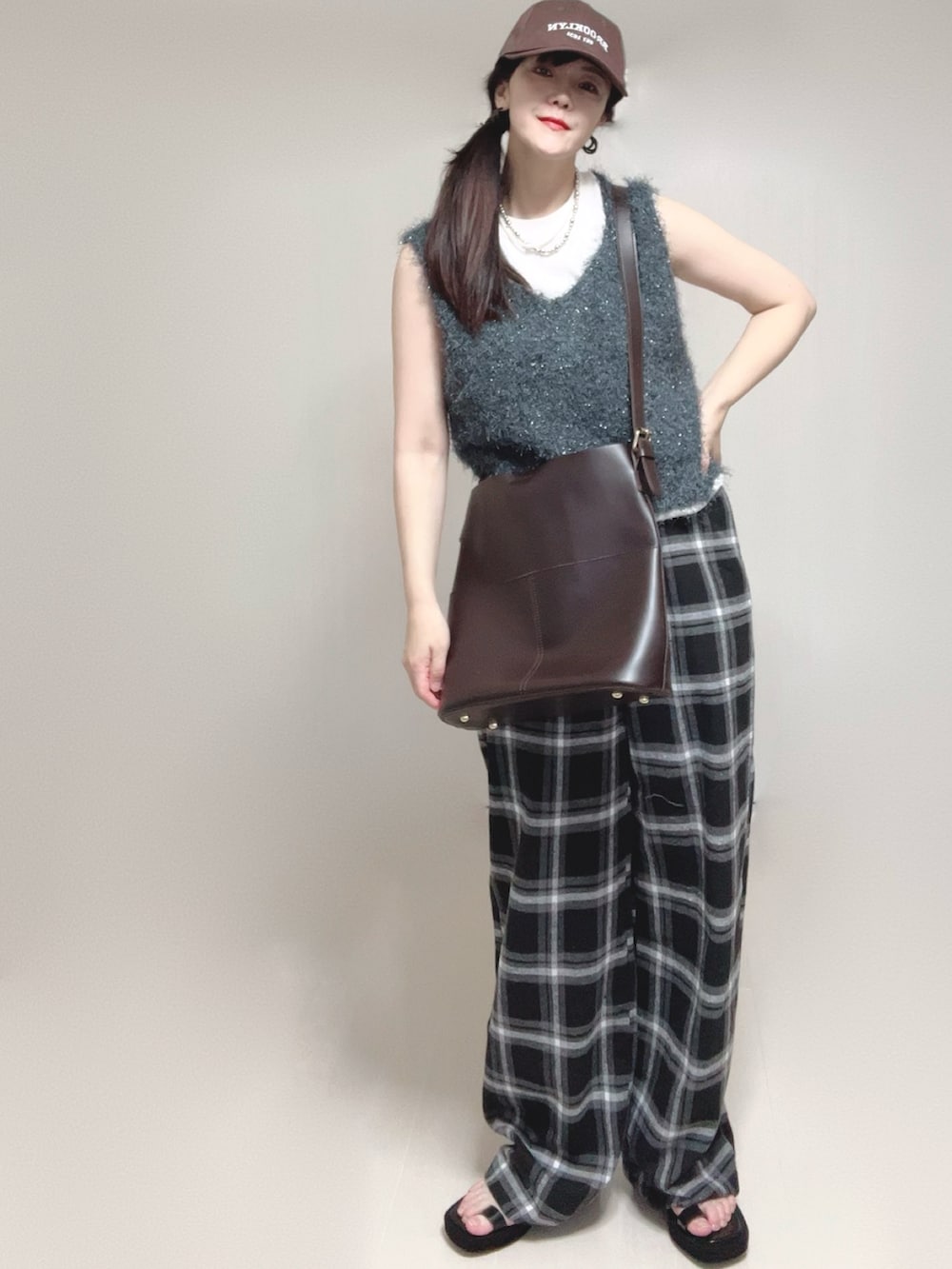 グレー系のベスト、ブラック系のサンダルを着用したレディースの夏コーディネートの4枚目の写真