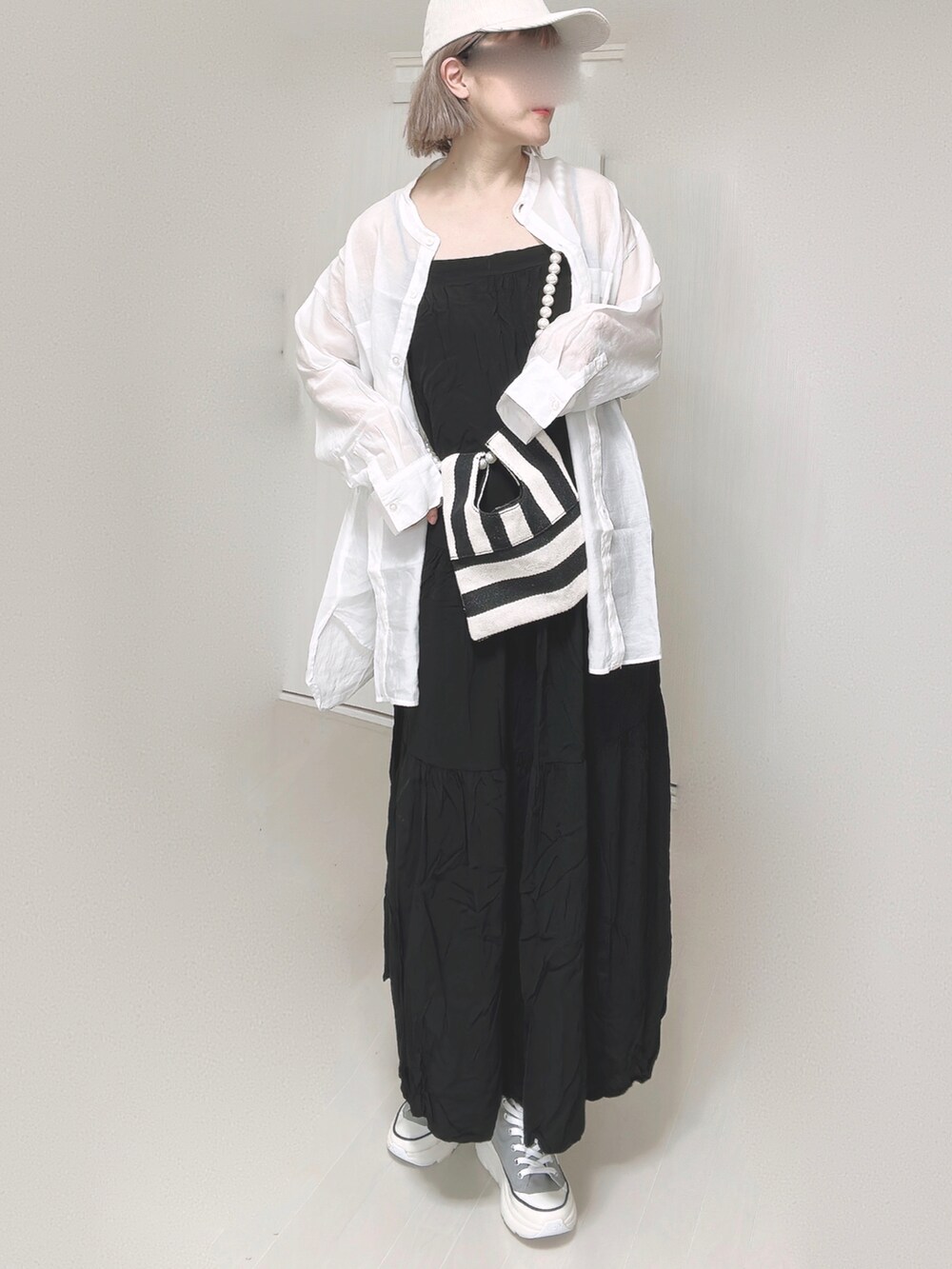 ブラック系のワンピース、ホワイト系のシャツ/ブラウス、ホワイト系のショルダーバッグを着用したレディースの春コーディネートの4枚目の写真