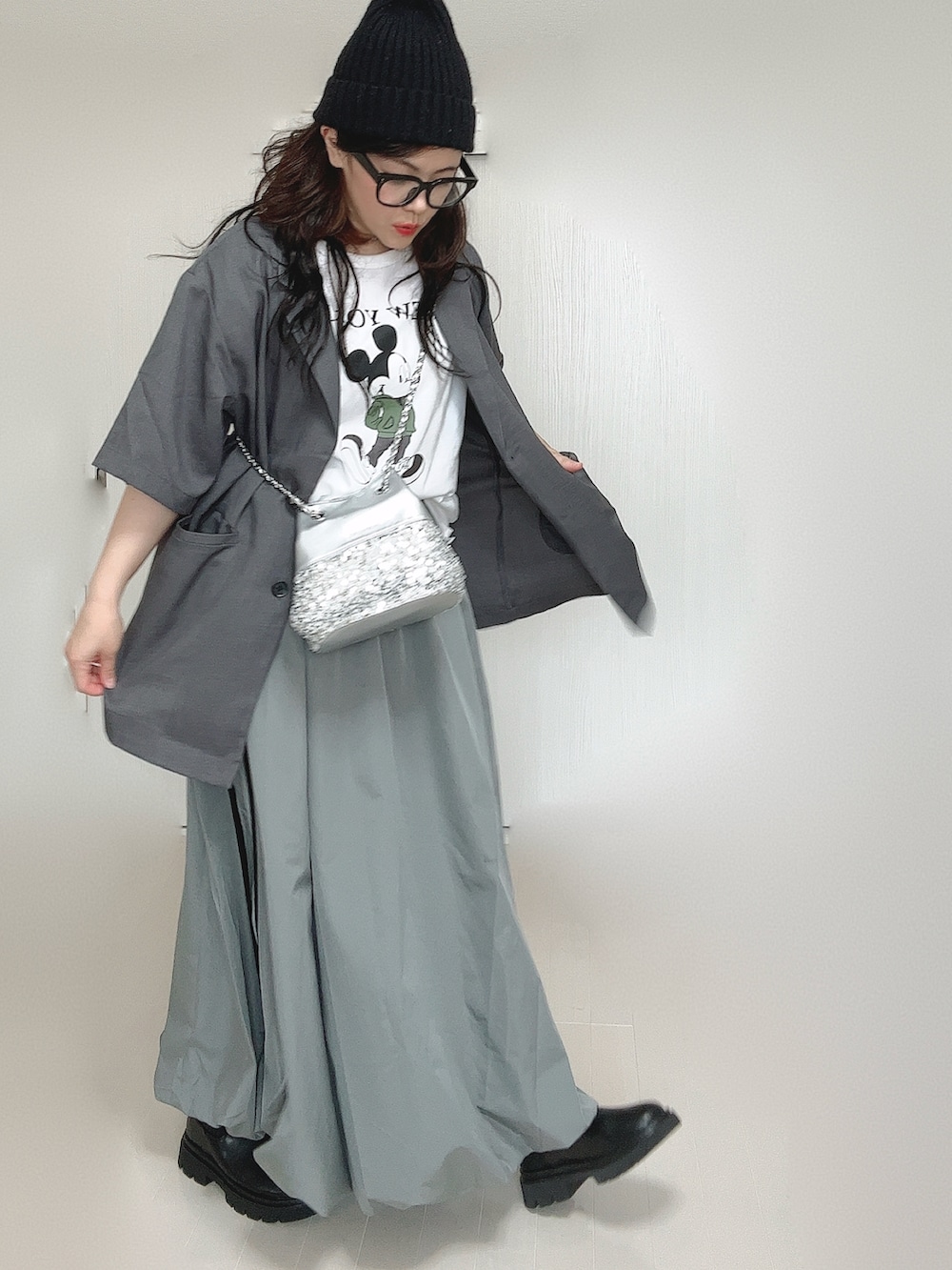 グレー系のテーラードジャケット、ブラック系のブーツ、ホワイト系のTシャツ/カットソーを着用したレディースの夏コーディネートの4枚目の写真