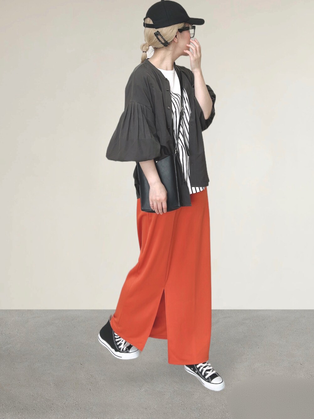 ホワイト系のTシャツ/カットソー、ブラック系のショルダーバッグ、オレンジ系のスカートを着用したレディースの秋コーディネートの3枚目の写真