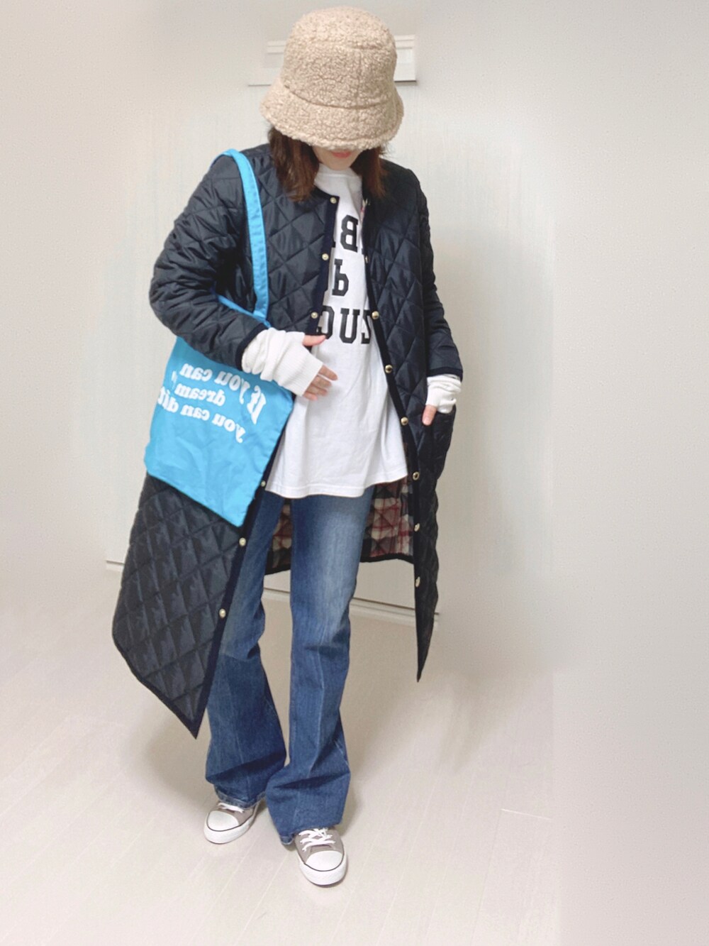 ブルー系のデニムパンツ、ブルー系のノーカラーコート、ホワイト系のTシャツ/カットソーを着用したレディースの秋コーディネートの5枚目の写真