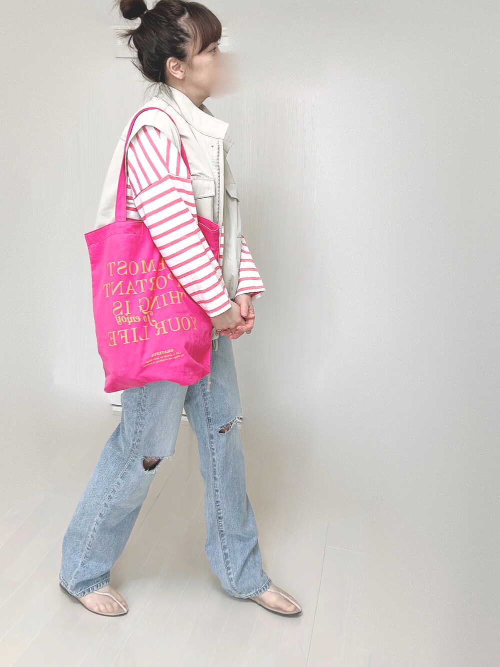 ブルー系のデニムパンツ、ホワイト系のベスト、ピンク系のTシャツ/カットソーを着用したレディースの春コーディネートの5枚目の写真